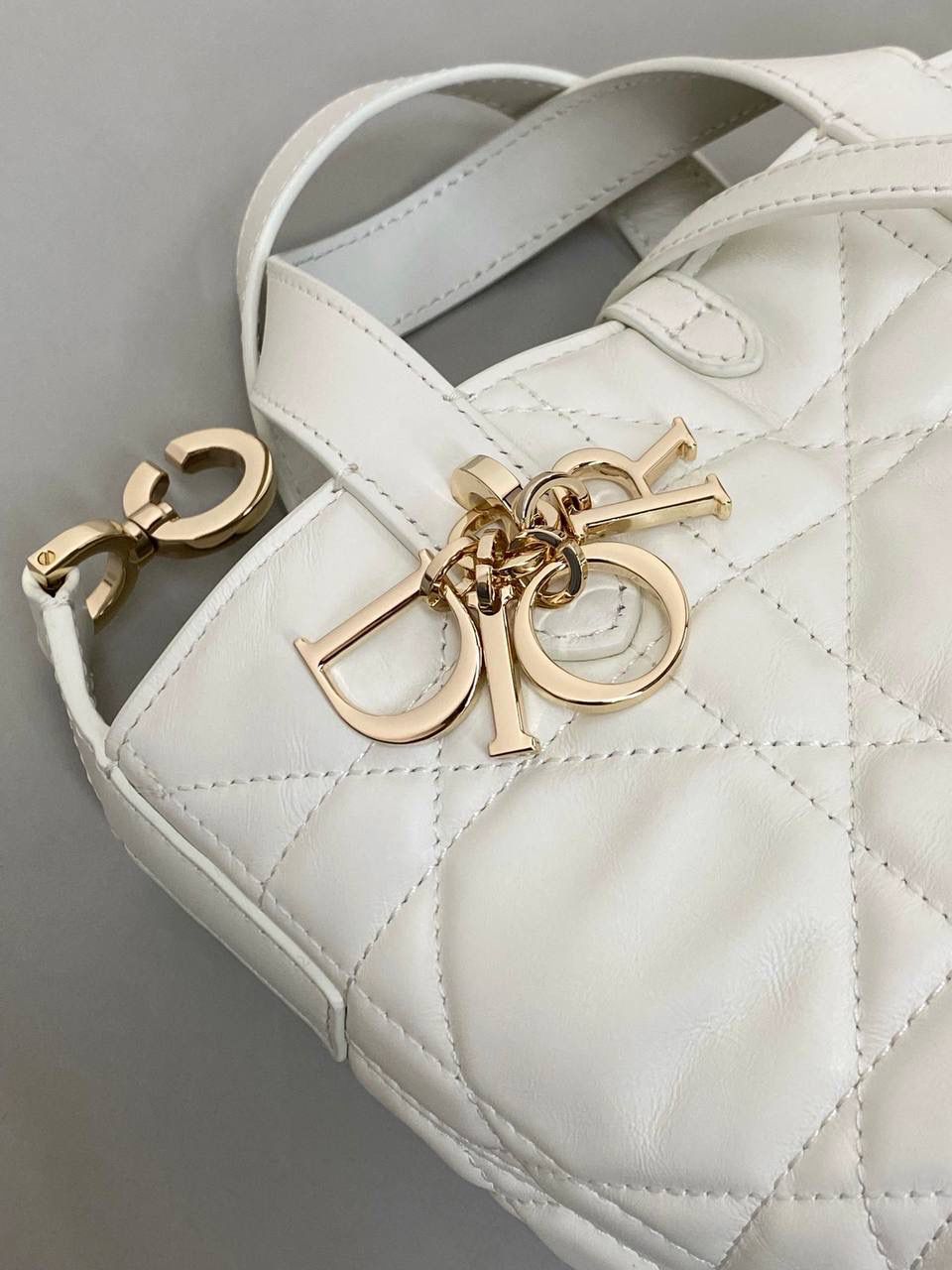 🈶白色，迷你 𝗗𝗜𝗢𝗥 𝗧𝗼𝘂𝗷𝗼𝘂𝗿𝘀新版竖款 火爆全网toujours缩小版来啦！ 看到真的心动得不行～ 实物就是常规迷你水桶大小， 真的可爱死 别说，包虽小但容量还挺大的 日常用品都能轻松装上 肩带长度也刚刚好，不挑身高 反正就是太乖啦！夏日必备 😍 13×15×12cm #M1272m