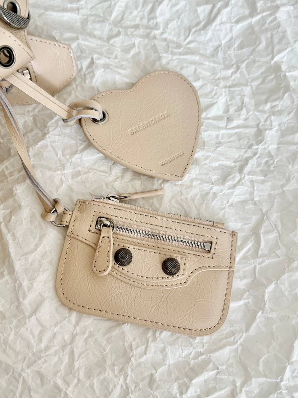 neo cagole 机车包xs奶茶色🥟 首先声明，我爱一切机车元素 无论是le cagole还是这只neo 喜欢大容量的姐妹冲这只 油蜡皮的不规则摔纹配上大量的五金配件 还有流苏拉牌➕爱心镜子➕零钱包挂件 极繁的魅力由此而来～ 辣妹酷妹冲冲！ 26×17.8×11.4cm700940m