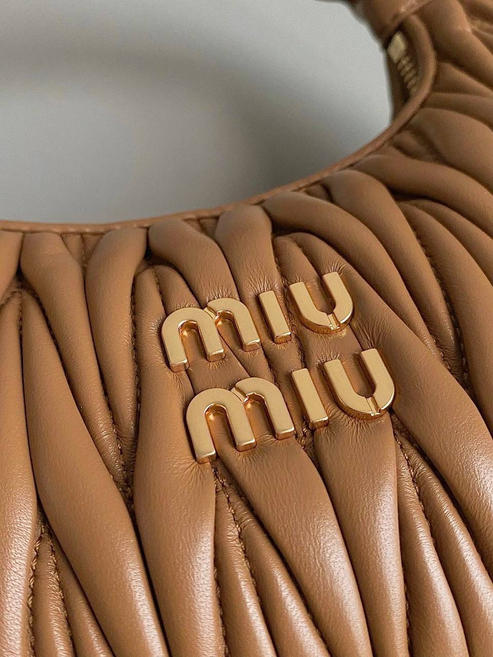 🈶焦糖小号 𝗠𝗶𝘂𝗠𝗶𝘂 𝗪𝗮𝗻𝗱𝗲𝗿 𝗛𝗼𝗯𝗼褶皱腋下 火爆全网都不用多说，人手一只的程度 我们用的是进口小羊皮！非国产皮料 肉眼可见的细腻，软软糯糯触感非常好！ 他家经典独特的褶皱工艺，是要有一定厚度 底料太薄了都做不出它的饱满和弹性 更不是市场通货干瘪瘪的褶皱，实在太假 我们新合作的老师傅在这细节上扣的很认真 一缕一折都有zp的神韵，且做到对版！！ 追求高品质的来 小号：17×20×6cm，#F0013m 中号：18x25x7cm