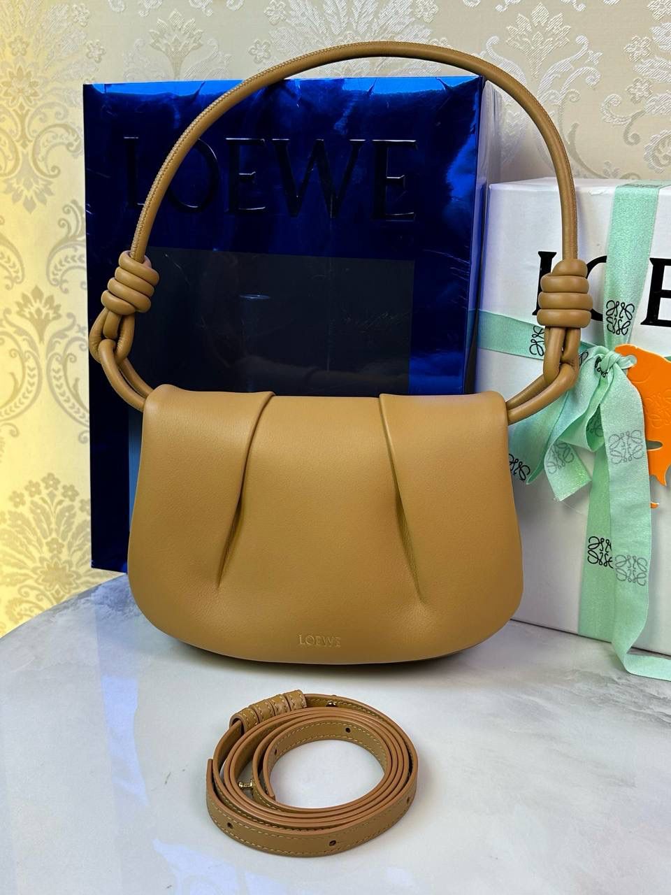 全新*𝙋𝙖𝙨𝙚𝙤 𝙨𝙖𝙩𝙘𝙝𝙚𝙡 手袋🛍️【棕色】 —— 朕品1w7➕😘 尺寸:𝟐𝟓-𝟏𝟕-𝟖𝐜𝐦 编码:062318【配全套礼盒】 ✅做工精致，廓形简洁优雅，独特、柔软的褶襇结构，超轻盈构造，纳帕软牛皮革（里外全皮），顶部饰有flamenco螺旋绳结。 ✅配置双肩带，短手柄肩带可做腋下包不可拆卸，长肩带可肩背可斜挎可拆卸调节，磁扣开合设计，多种背法随心所欲❤