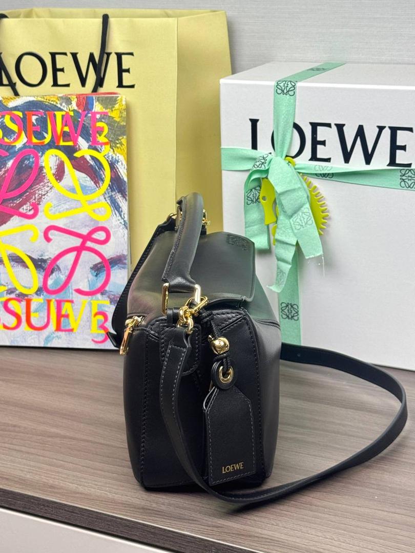 🎈【周年限定】 小号纳帕羊皮𝗙𝗲𝗮𝘁𝗵𝗲𝗿𝗹𝗶𝗴𝗵𝘁 𝗣𝘂𝘇𝘇𝗹𝗲手袋👜 ——黑色到货❤️ 尺寸：𝟮𝟰-𝟭𝟬.𝟱-𝟭𝟲.𝟱𝗰𝗺 编码：061610【配全套礼盒】 ✅延续经典老款𝗣𝘂𝘇𝘇𝗹𝗲做法，全新𝗣𝘂𝘇𝘇𝗹𝗲内外采用柔软轻盈的纳帕羊皮材质，为手袋注入随性慵懒的风格。 ✅该款饰有旋转卡扣，铰链式拉链头，一个外部拉链后袋，一个内部插袋，以及可拆卸式的𝗟𝗢𝗘𝗪𝗘烫金或烫银标签，饰有隐秘口袋和气球骰子，底部长方形金属脚钉。搭配可拆卸可调节长肩带，可肩背、斜挎或手提。