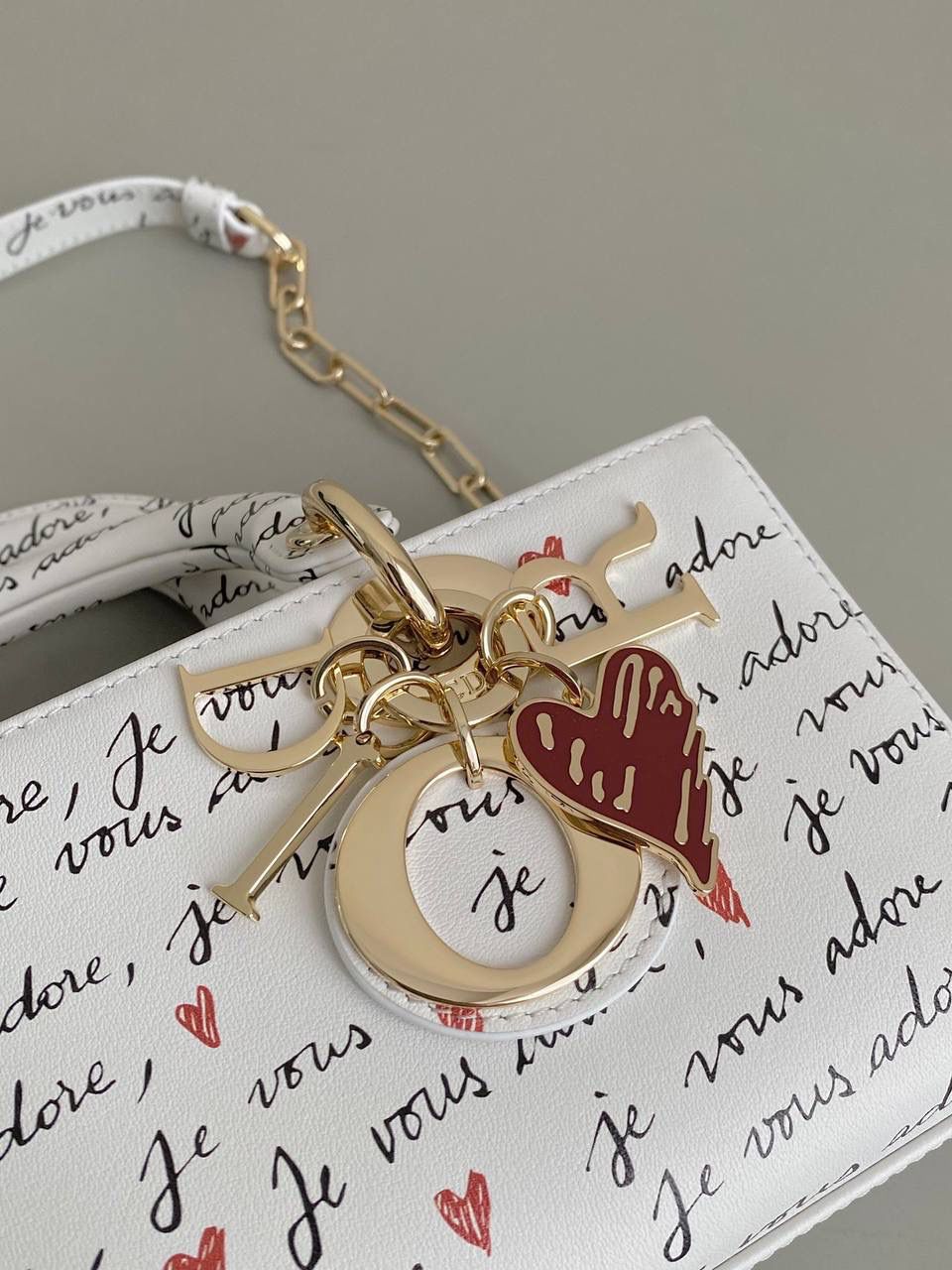 爱心白🎀𝗗𝗜𝗢𝗥 𝗗-𝗝𝗼𝘆小号 七夕限定，更是每一天的爱意限定 情书💌款这种淡淡的色调好梦幻 从印花到纯色都散发着治愈的气息 刻印的纹理感，伸手可触 连绵不断的法语我爱你'点缀着爱心❤️ 是写满了法式浪漫的包包呀！ 请拥有，这独一份的爱意 22×12×6cm