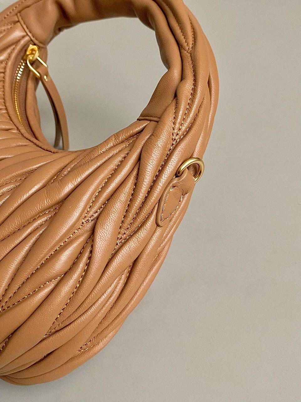 🈶焦糖小号 𝗠𝗶𝘂𝗠𝗶𝘂 𝗪𝗮𝗻𝗱𝗲𝗿 𝗛𝗼𝗯𝗼褶皱腋下 火爆全网都不用多说，人手一只的程度 我们用的是进口小羊皮！非国产皮料 肉眼可见的细腻，软软糯糯触感非常好！ 他家经典独特的褶皱工艺，是要有一定厚度 底料太薄了都做不出它的饱满和弹性 更不是市场通货干瘪瘪的褶皱，实在太假 我们新合作的老师傅在这细节上扣的很认真 一缕一折都有zp的神韵，且做到对版！！ 追求高品质的来 小号：17×20×6cm，#F0013m 中号：18x25x7cm