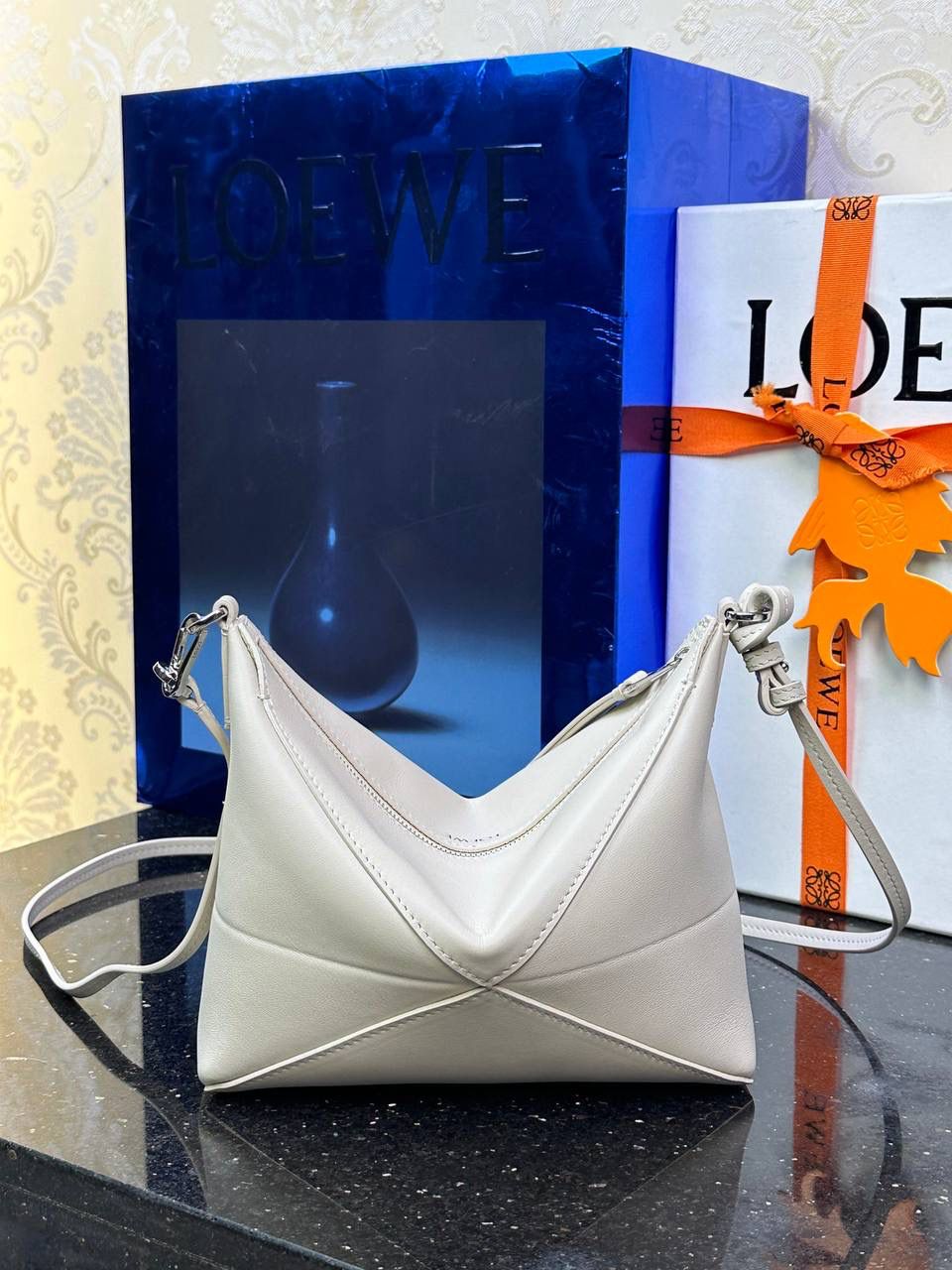 ♥️𝙋𝙪𝙯𝙯𝙡𝙚 𝙁𝙤𝙡𝙙 ——【海盐白】 尺寸：𝟐𝟑-𝟔.𝟓-𝟏𝟓.𝟓𝐜𝐦 编码：522404 🎈经典几何为造型，以及柔软细腻的Napa牛皮，升级为可完全折叠的手拿包。 🎈自带一根🉑拆卸🉑调节的肩带，一包多背，多样化风格，秀场大放异彩😃日常实用性强👌 🎈配全套专柜礼盒🎁，给你满满的仪式感👀