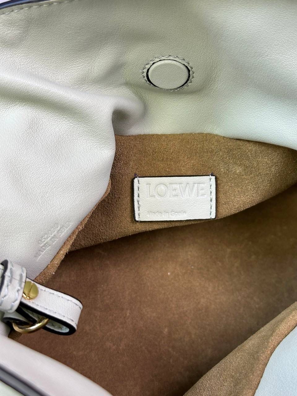 Flamenco clutch-NEW ✦迷你✦ 尺寸：𝟐𝟐.𝟓-𝟏𝟖-𝟗𝐜𝐦 型号：052030亮灰绿 ❤️mini flamenco clutch bag 可手拿亦可优雅斜挎 云朵般温暖亦轻盈的造型如此简单，💯耐看💯不会out的款式！ ❤️包袋采用进口小牛皮，手感如羊皮般细腻柔软，却比羊皮更加结实耐用，麂皮内衬 ❤️品牌标志性绳结设计，收紧袋口就是小福袋造型，超Q，看着不大实际超会装😇