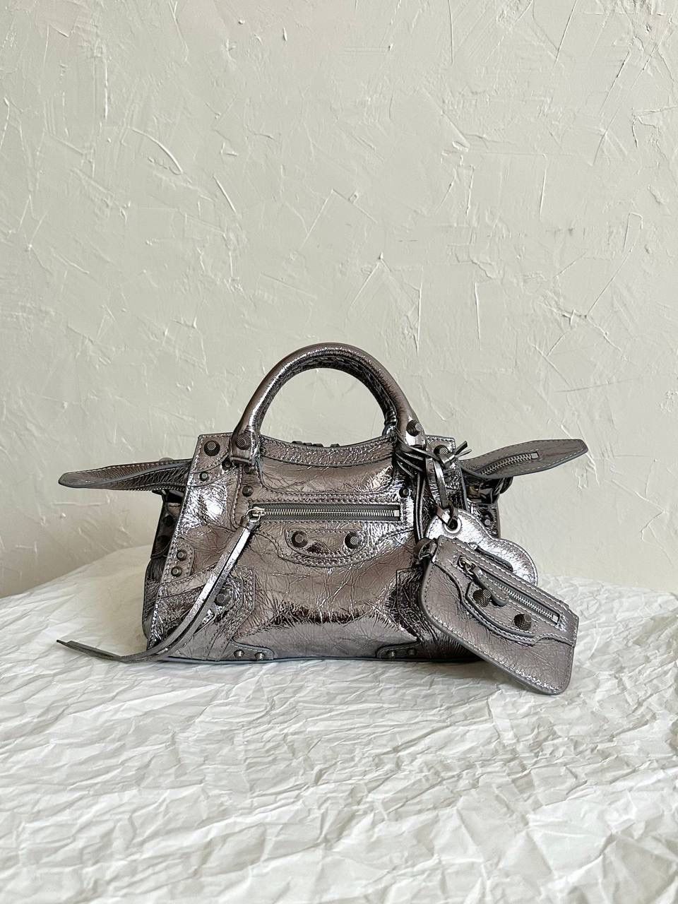 ba1enciaga Neo classic 机车包xs 古银扣🌪️ 首先声明，我爱一切机车元素 无论是le cagole还是这只neo 喜欢大容量的姐妹冲这只 油蜡皮的不规则摔纹配上大量的五金配件 还有流苏拉牌➕爱心镜子➕零钱包挂件 极繁的魅力由此而来～ 辣妹酷妹冲冲！ 26×17.8×11.4cm700940m