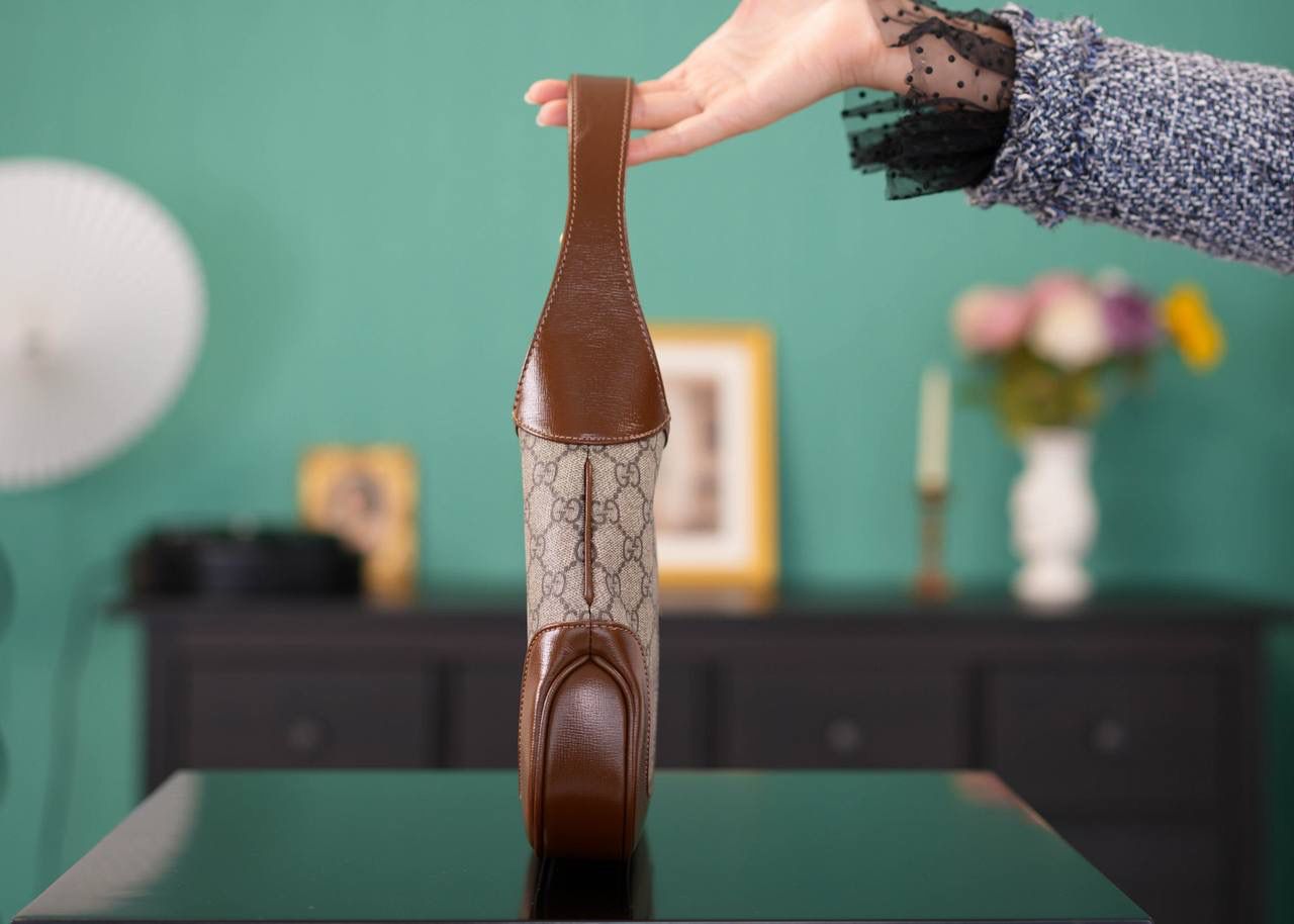 🥯GG Jackie 1961系列小号手袋 棕色28cm 正品售价,200 经典𝙅𝙖𝙘𝙠𝙞𝙚是爱豆们最近的心头好 绿红织带复古设计 将60年代的气息与现代的时尚融合交汇 不仅让人感受到浓郁的复古美感， 还多了时尚潮流的气息，结合起来真的是非常赞！！！ 两条肩带设计，腋下背单肩背多风格背法~ 官方款号 636706 尺寸：28x19x4.5cm