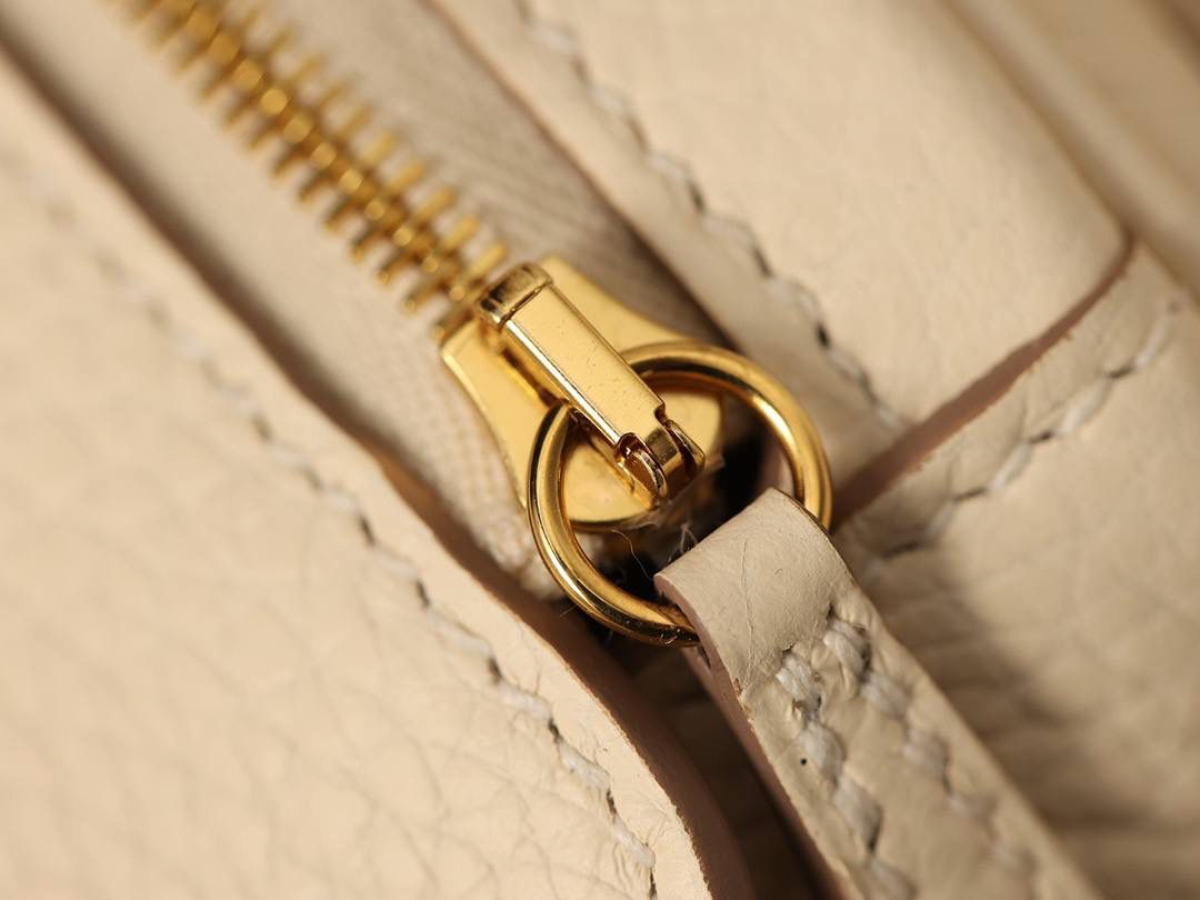 Hermes 爱马仕 Lindy 26cm 奶油白金扣👜✨ 尺寸：26*18*14 cm 奶油白真的实物很漂亮，YYDS😍 五金介绍，拉链尾部的"H"是刚好的正方形，而且每笔都是很直，菱角分明，表明平整 图二至六图的的五金四个小螺丝是人工围着这四个小圆点边雕琢上去的，而且小螺丝这点的周围圈是有孤独深的圆形，这点很多人都不知道，这个是符合正品工艺的 拉链是纯原装金扣的RIRI拉链 所以在五金方面我们拿捏的死死的 无人能敌 🤟🏻 渠道货是注重任何一个细节的 做到任何人都做不到的点 这就是天花板😍💯👍