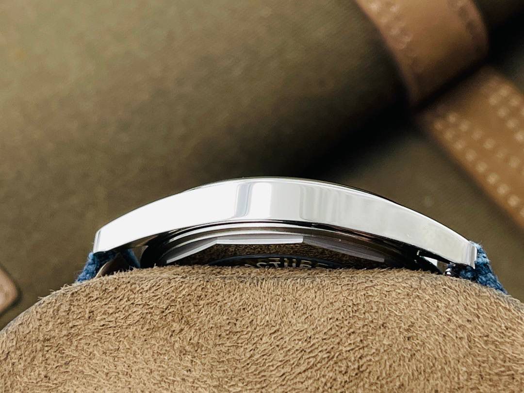 百达翡丽2021新品——Ref.6007A-001（普朗莱乌特制表大楼纪念款）腕表🔥🔥 ✅表径尺寸：40毫米 ✅表镜配置：蓝宝石水晶玻璃表镜，背面刻有卡拉特拉瓦十字星图案，以及“New manufacture 2019”字样，细节还原到位 ✅表壳设计：316L精钢打造表壳，搭配宽阔的弧形表圈，质感扎实 ✅表盘特色：标志性灰蓝色素面设计，搭配精致的圆形缎面打磨工艺，简约大气 🌟 技术突破 搭载第三代324S定制一体机芯，不仅仿真度极高，走时精准稳定，兼顾颜值与实用性 🌟 表带与表扣 搭配灰蓝色小牛皮表带，辅以白色缝线装饰，搭配百达翡丽（PP）经典针扣设计，与表盘色彩相互呼应🤟🏻