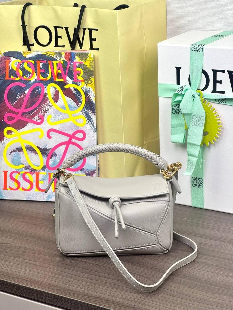 🎈最新编织手腕𝙈𝙞𝙣𝙞 𝙋𝙪𝙯𝙯𝙡𝙚 ——【银灰色】 尺寸：𝟏𝟖-𝟏𝟐.𝟓-𝟖𝐜𝐦 编码：062401【配全套礼盒】 ♥️以罗家经典几何设计，搭配独特的编织手腕，绒面内里。 ♥️容量大，经典百搭，可拆卸肩带，有单肩，斜挎，手提等多样化背法。随性时髦洒脱，实用性强。 ♥️独家背景➕独家品质➕独家全套砖柜礼盒套装，市场高端品质皆在我手✌🏻