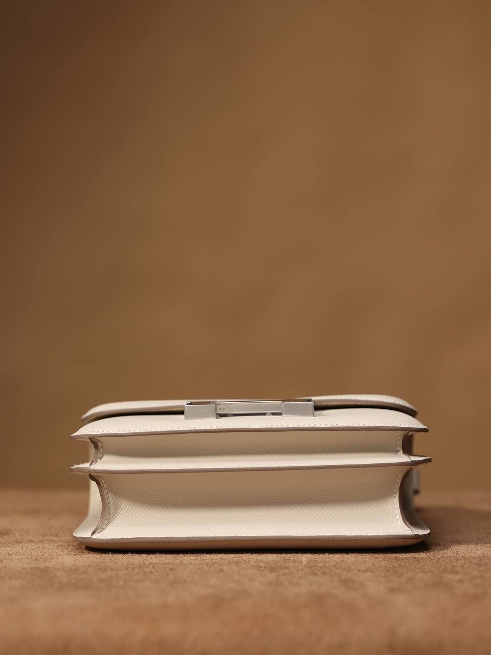 Hermes 爱马仕 #Constance 19奶昔白银扣👜✨ Epsom牛皮 单肩斜挎包 尺寸：19*15*4 cm 这款采用的是Epsom牛皮,纯原皮，和专柜用的是一个渠道的真皮 什么是Epsom牛皮？ 皮质：ep皮/手掌纹、一岁以上的公牛皮 软硬度：偏硬 纹理：皮面颗粒小的细腻皮纹，有点光泽感 特点：硬朗有细纹的牛皮皮质。细纹是进过后期处理的，比较硬质立体，长期贮存也不容易变形。自重轻，不易刮伤，非常耐磨实用。 所以每个H的款式用的皮都不一样，都是非常有讲究的✅