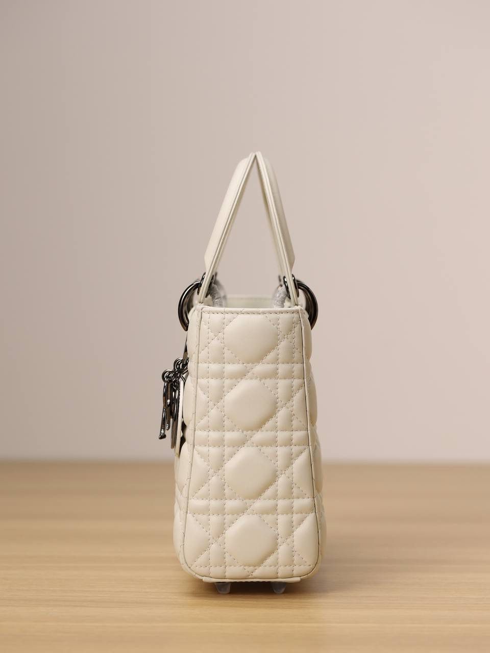 小号 LADY DIOR MY ABCDIOR 手袋 奶白色羊皮革藤格纹 独家渠道货 四格戴妃包白色羊皮枪扣 尺寸：20 x 17 x 8 厘米 这款 Lady Dior My ABCDior 手袋彰显 Dior 经典标识。 款式时尚精致，是一款经久不衰的单品。 采用奶白色羊皮革精心制作，搭配藤格纹缉面线，精良的绗缝质感显露无遗。 饰以金属覆层D.I.O.R.吊饰，为醒目的轮廓增添一分灵动💕💕