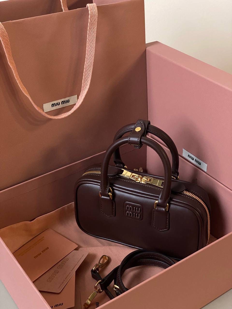 🈶石南木色，迷你 𝗠𝗶𝘂𝗠𝗶𝘂保龄球，大爆款 新尺寸也太可爱了！ 喜欢小包的姐妹这只必买！它要比小号小一些也窄一些 就巴掌大小，但容量还挺大的 装俩部手机都绰绰有余，日常够用 肩带长短也很ok，手拎斜挎都好看 反正放心冲就是了！拥有它，上班牛马的心情都会被治愈～ 迷你：19×10×5cm #F0011m 小号：22x10.5x7.5cm 大号：27x12x9cm