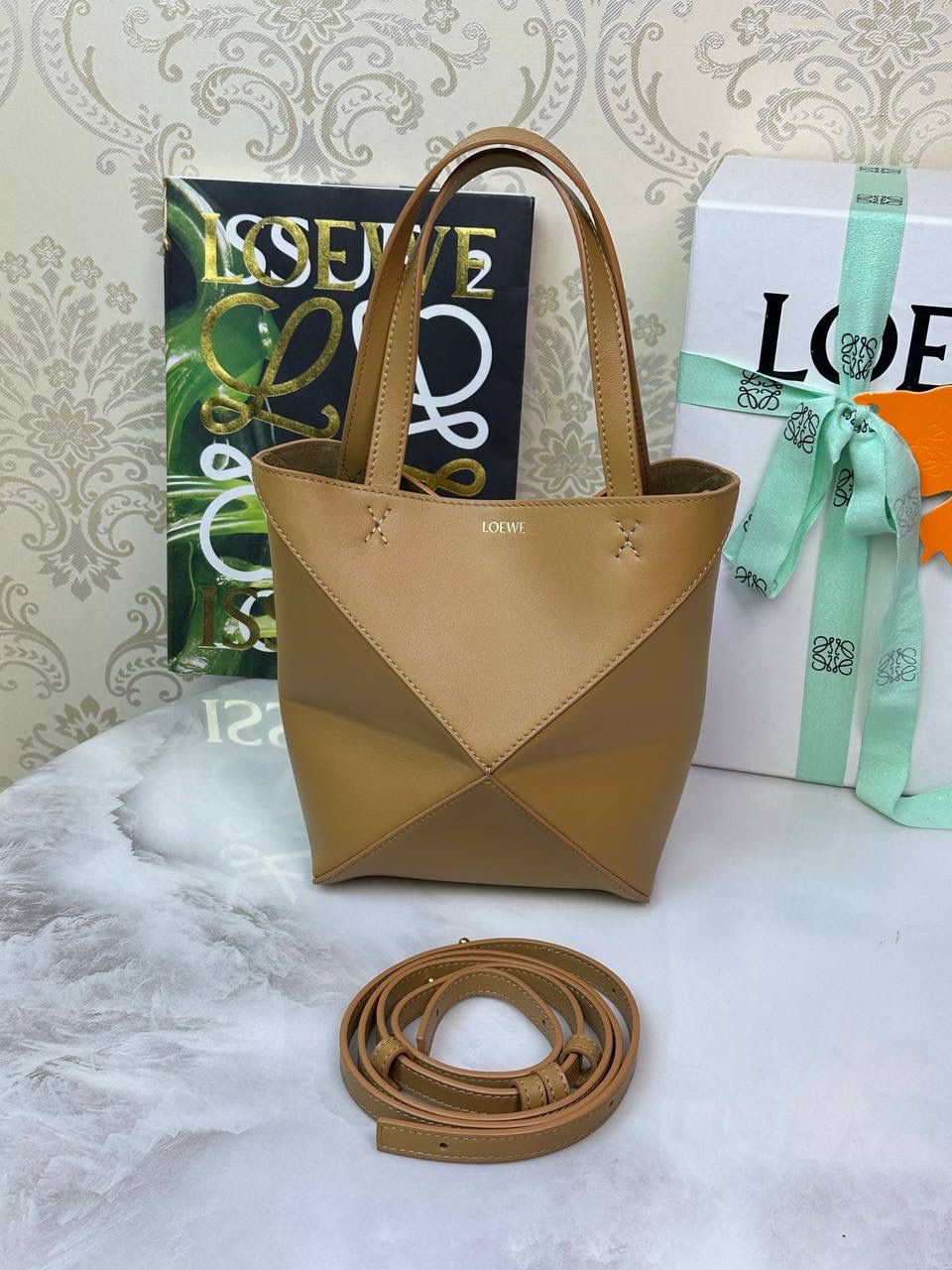 *𝐌𝐢𝐧𝐢 𝐏𝐮𝐳𝐳𝐥𝐞 𝐅𝐨𝐥𝐝折叠手袋👜* ——全新【𝗡𝗘𝗪】升级‼️ 延续经典𝙋𝙪𝙯𝙯𝙡𝙚的标志性几何裁剪设计，新晋顶流🅰️𝙋𝙪𝙯𝙯𝙡𝙚 𝙁𝙤𝙡𝙚 𝙏𝙤𝙩𝙚以折纸包为灵感，升级成🉑完全折叠‼️的结构，立体与平面任意切换，出差旅行🧳必备单品。小牛皮材质轻且柔软，𝐌𝐢𝐧𝐢尺寸搭配一条可拆卸式肩带，手提，肩背，斜挎多样化背法✨ 尺寸：𝟏𝟔.𝟓-𝟗.𝟓-𝟐𝟎cm 款号：052322