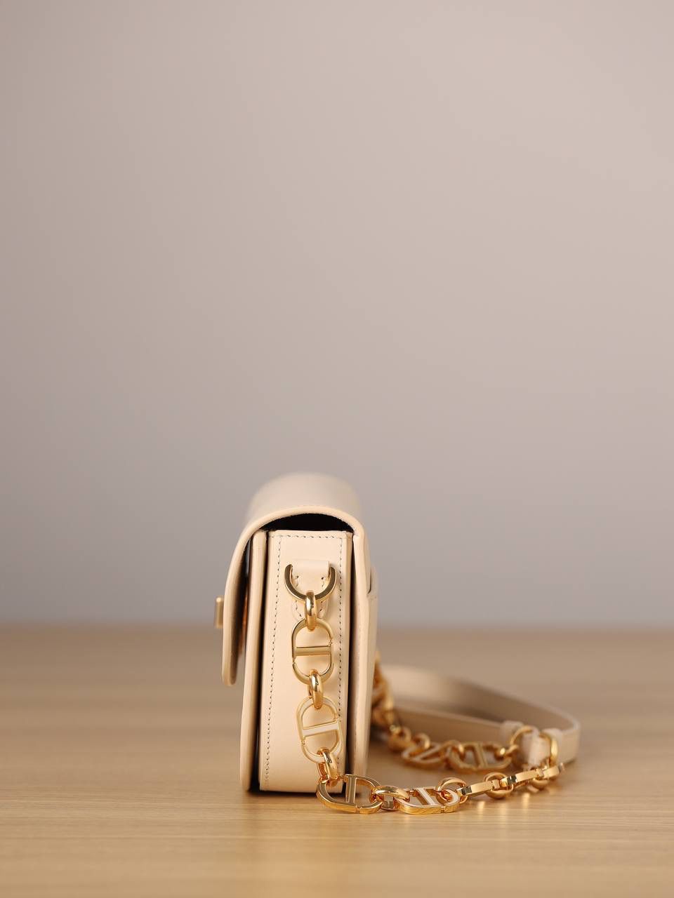 30 MONTAIGNE AVENUE 手袋 灰象牙色光面牛皮革👜✨ 独家渠道货 独家蒙田腋下包白色珐琅扣 尺寸：22.5 x 12.5 x 6.5 厘米 这款 30 Montaigne Avenue 手袋采用典雅的设计，提升此经典系列的格调。 采用黑色光面牛皮革精心制作，圆角翻盖曲线精致，饰以复古金色饰面金属 CD 扣环，灵感源自 Christian Dior 香水瓶的封口。 背面饰以压花 30 Montaigne 标志，搭配由金色饰面金属和与皮革同色调的珐琅链环交替组成的经典链条。 褶层设计，空间宽敞，廓形精致，可手提，肩背或斜挎。