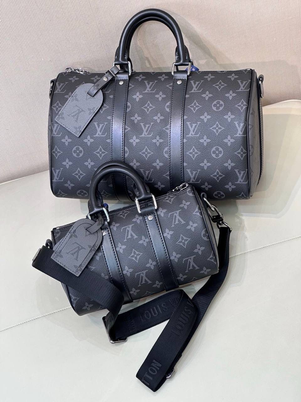 LV Keepall 黑老花系列 🖤✨ 潮男最爱款，男女都能背 😎 低调黑老花拼灰色，帅气又百搭， 小巧但很能装，随便一背就很有型，凹造型神器 💯 经典 Eclipse Reverse 帆布，老花两侧倒置设计，低调中带一点小巧思～牛皮包边＋宽肩带，背重也不累 👍配皮革手柄＋可拆可调节肩带，手提、肩背、斜挎都行 📏 尺寸 小号：25 × 15 × 11 cm 中号：35 × 17 × 21 cm