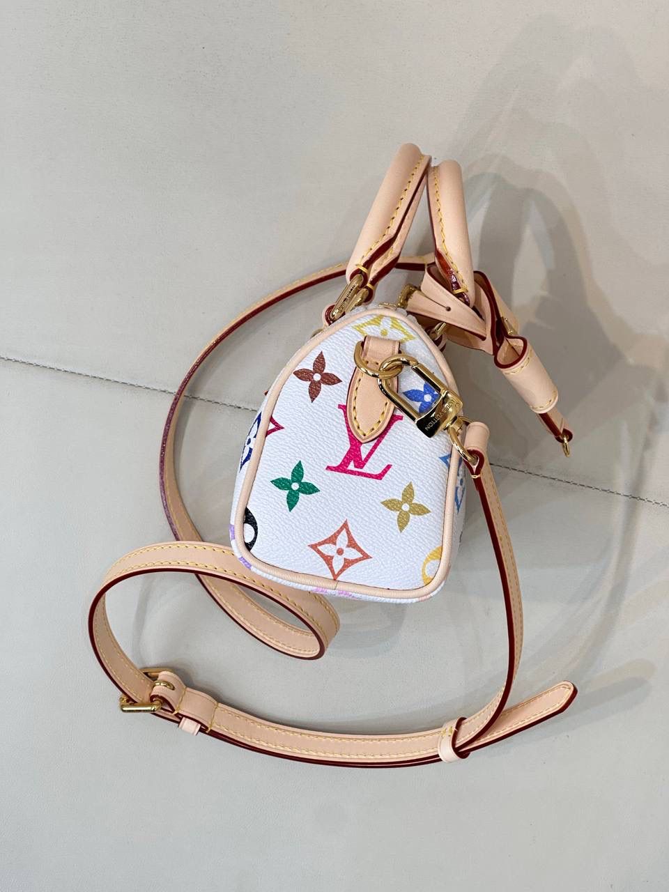 LV村上隆联名白三彩Nano Speedy来啦！姐妹们快看这个神仙包包！👜🌈 白色打底+彩色老花图案，配上祖传小锁头钥匙包，简直是《Mean Girls》千禧辣妹的标配！全新数码印花绝绝子，太阳花和熊猫都像要跳出来，阳光下自带ins滤镜特效！别看它巴掌大，手机口红💄钥匙全塞得下，从此打脸那些说mini包不实用的人！ 尺寸：16-10-7.5cm