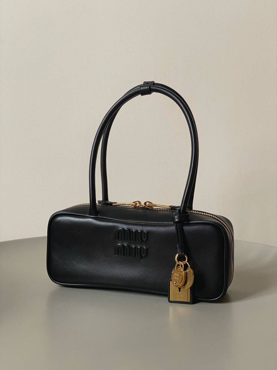 🈶黑色 𝗠𝗶𝘂𝗠𝗶𝘂保龄球| 吊饰版 说是公文包.更是保龄球！ 虽倆者都早已大火全网时髦圈哈哈 今年这只长手柄保龄球能买到就是赚到咯！ 细长的手柄整体更秀气了 还送了一串吊饰 是一把锁头还有一个爱心， 上面都有logo刻印很精致也很厚重 宝子们再也不愁买挂饰啦！ 28×11.5×8cm #F0010m