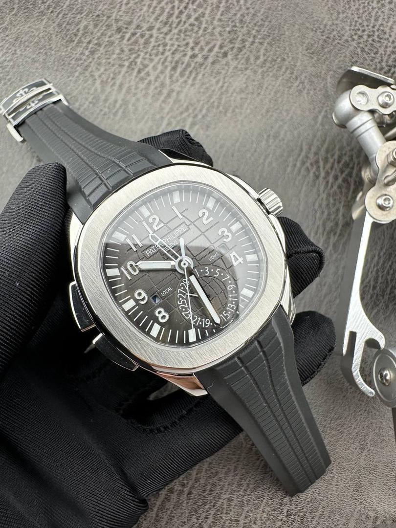 百达翡丽Aquanaut系列😎 【表壳】40.8MM表径，不锈钢材质，圆润的八角壳型恰到好处，表壳左侧的鲨鱼鳍型设计，是可以前后快调中央镂空时针的按钮，这枚指针可以用来指示第二时区时间。 【表盘】黑色浮雕表盘，金属立体字块，覆荧光涂层时标。3、9点钟分别显示”HOME”与”LOCAL”的方形昼夜视窗，蓝白二色各自代表晚上与白天，6点钟位置是指针式的日期盘。 【机芯】成功实现百达翡丽5164A-001内载的324 SC FUS自动上链机芯功能，大三针基础机芯上搭载两地时间模组。 配有休闲气息的Tropical表带，正是为年轻世代所准备的奢华运动表。
