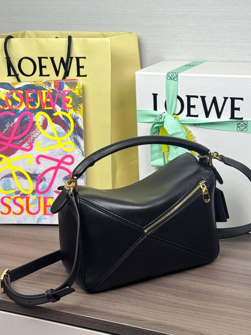 🎈【周年限定】 小号纳帕羊皮𝗙𝗲𝗮𝘁𝗵𝗲𝗿𝗹𝗶𝗴𝗵𝘁 𝗣𝘂𝘇𝘇𝗹𝗲手袋👜 ——黑色到货❤️ 尺寸：𝟮𝟰-𝟭𝟬.𝟱-𝟭𝟲.𝟱𝗰𝗺 编码：061610【配全套礼盒】 ✅延续经典老款𝗣𝘂𝘇𝘇𝗹𝗲做法，全新𝗣𝘂𝘇𝘇𝗹𝗲内外采用柔软轻盈的纳帕羊皮材质，为手袋注入随性慵懒的风格。 ✅该款饰有旋转卡扣，铰链式拉链头，一个外部拉链后袋，一个内部插袋，以及可拆卸式的𝗟𝗢𝗘𝗪𝗘烫金或烫银标签，饰有隐秘口袋和气球骰子，底部长方形金属脚钉。搭配可拆卸可调节长肩带，可肩背、斜挎或手提。