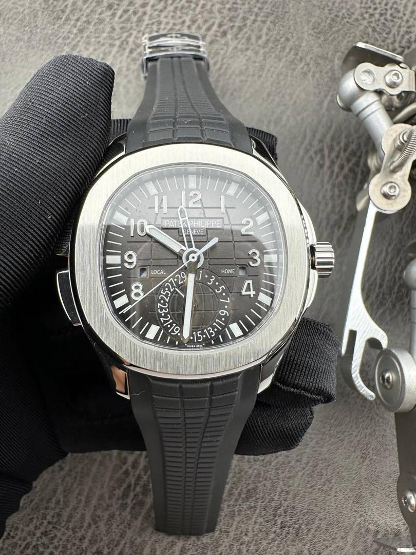 百达翡丽Aquanaut系列😎 【表壳】40.8MM表径，不锈钢材质，圆润的八角壳型恰到好处，表壳左侧的鲨鱼鳍型设计，是可以前后快调中央镂空时针的按钮，这枚指针可以用来指示第二时区时间。 【表盘】黑色浮雕表盘，金属立体字块，覆荧光涂层时标。3、9点钟分别显示”HOME”与”LOCAL”的方形昼夜视窗，蓝白二色各自代表晚上与白天，6点钟位置是指针式的日期盘。 【机芯】成功实现百达翡丽5164A-001内载的324 SC FUS自动上链机芯功能，大三针基础机芯上搭载两地时间模组。 配有休闲气息的Tropical表带，正是为年轻世代所准备的奢华运动表。