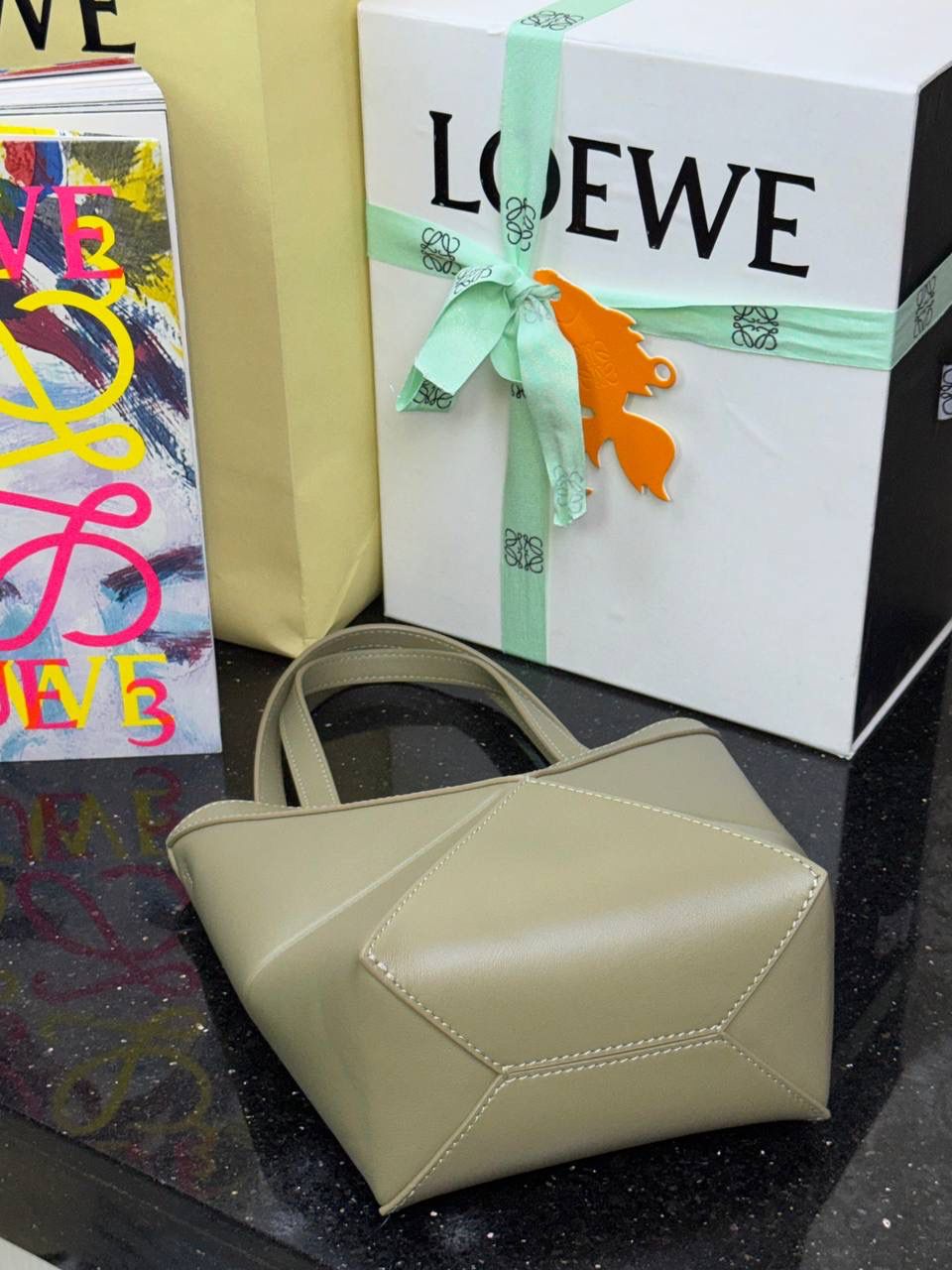 *𝐏𝐮𝐳𝐳𝐥𝐞 𝐅𝐨𝐥𝐝折叠手袋👜* ——全新【𝗡𝗘𝗪】升级‼️ 延续经典𝙋𝙪𝙯𝙯𝙡𝙚的标志性几何裁剪设计，新晋顶流🅰️𝙋𝙪𝙯𝙯𝙡𝙚 𝙁𝙤𝙡𝙚 𝙏𝙤𝙩𝙚以折纸包为灵感，升级成🉑完全折叠‼️的结构，立体与平面任意切换，出差旅行🧳必备单品。小牛皮材质轻且柔软，𝐌𝐢𝐧𝐢尺寸搭配一条可拆卸式肩带，手提，肩背，斜挎多样化背法✨ 尺寸：𝟏𝟔.𝟓-𝟗.𝟓-𝟐𝟎cm 款号：052322