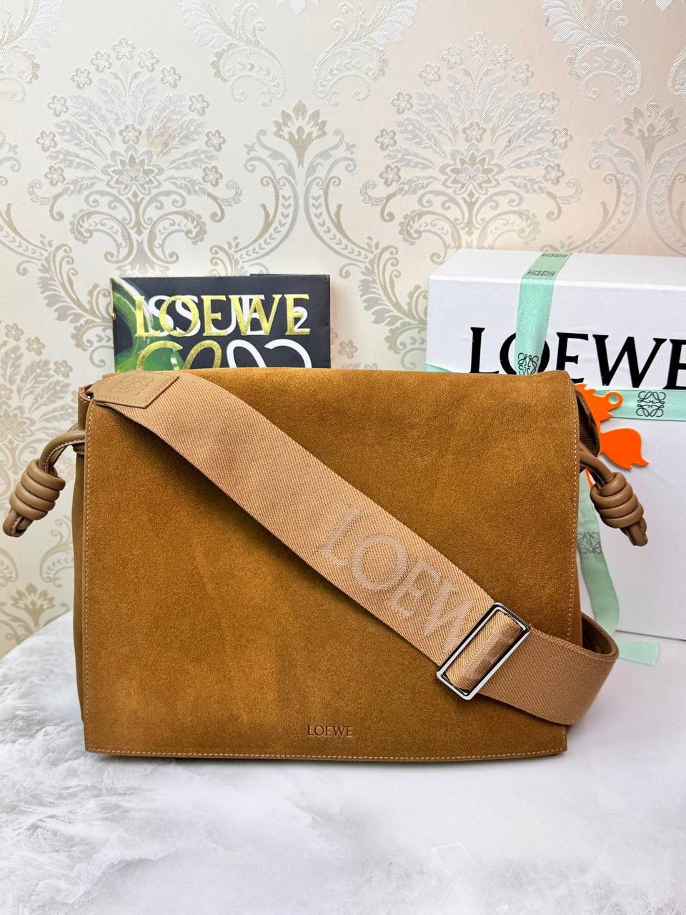 𝙇𝙤𝙚𝙬𝙚 𝙁𝙡𝙖𝙢𝙚𝙣𝙘𝙤 𝙎𝙖𝙩𝙘𝙝𝙚𝙡 福袋款邮差包 ➕刺绣🅾️字母宽肩带 编码：062404 尺寸：𝟑𝟒-𝟏𝟐-𝟐𝟒𝐜𝐦 新款以经典福袋收缩打结为元素，采用外部麂皮➕内里𝗡𝗮𝗽𝗮小牛皮➕刺绣字母宽肩带的精致搭配打造全新升级款邮差包🅰️，可斜挎、肩背和手提，超大容量满足日常所需🎈