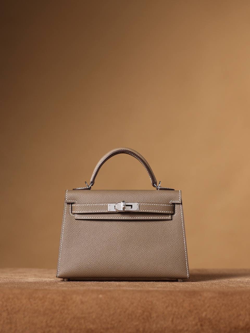 HERMES 爱马仕 Mini Kelly 二代 👜✨ Mini Kelly 二代 大象灰银扣 高清实拍图 尺寸：19*12*6cm Hermès爱马仕是世界著名的奢侈品品牌，1837年由Thierry Hermès创立于法国巴黎。爱马仕早年以制造高级马具起家，迄今已有180年的悠久历史。 其整个品牌从整体到细节以及专卖店，都弥漫着浓郁的以马文化为中心的深厚底蕴🎀