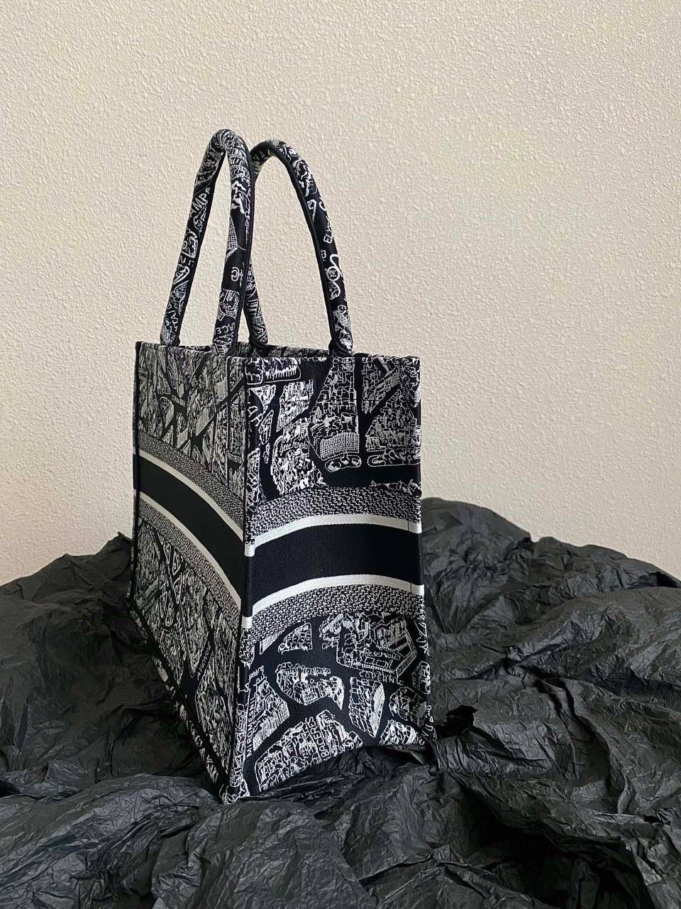 🈶黑色中号 𝗖𝗗 𝗕𝗼𝗼𝗸 𝗧𝗼𝘁𝗲 23夏季"巴黎地图"🖤 说实话，近年来花卉系列有点看乏看腻的 请你们一定看看这一只，新的炙热款！！ 本季主打的巴黎第八街区地图，惊艳了全网 真真实实绣在整个包上，砖柜超级难抢的！ 黑白色调干净利落，复古又神秘的法式浪漫 那种高定视觉，沦陷了！沦陷了！ 行走的巴黎街头很是时髦，我先冲了！😍😍 36×27×16cm