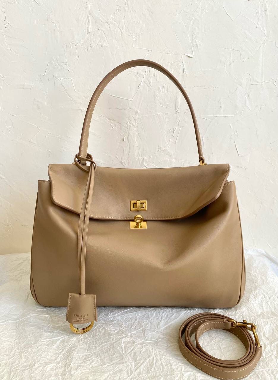 销量王🔥 ba1enciaga rodeo中号奶茶色🏉 准准的大爆款，大家都知道吧 哎呀，每次遇到这种超好看的大爆款 就很想在买版的那一刻 就立马能开发出来给你们背！ 去专柜试背了一下三个尺寸 160的个子觉得小号中号都可以 小号更优雅气质，手提斜挎都好看 中号就更松弛慵懒，腋下背好看！ 中号是可以放a4书本和13寸的笔记本的 163以上，喜欢大包的姐妹果断敢敢的冲大号！ 中号：35×23.3×10.9cm789772m 小号：28.9×20×9.9cm789779m mini：23×17×9cm795456m