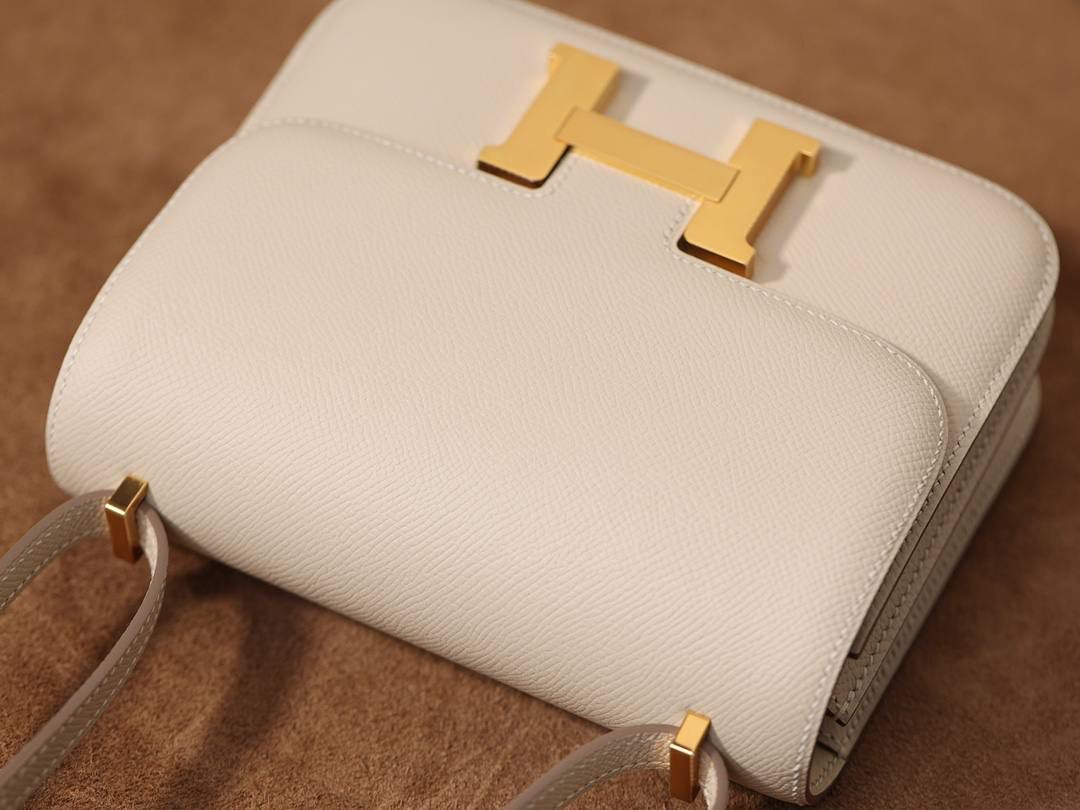 Hermes 爱马仕 #Constance 19奶昔白金扣👜✨ Epsom牛皮 单肩斜挎包 尺寸：19*15*4 cm 这款采用的是Epsom牛皮,纯原皮，和专柜用的是一个渠道的真皮 什么是Epsom牛皮？ 皮质：ep皮/手掌纹、一岁以上的公牛皮 软硬度：偏硬 纹理：皮面颗粒小的细腻皮纹，有点光泽感 特点：硬朗有细纹的牛皮皮质。细纹是进过后期处理的，比较硬质立体，长期贮存也不容易变形。自重轻，不易刮伤，非常耐磨实用。 所以每个H的款式用的皮都不一样，都是非常有讲究的✅