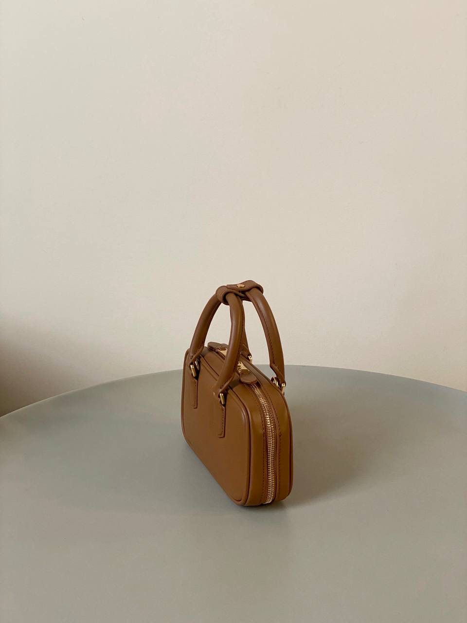 🈶干邑色，迷你 𝗠𝗶𝘂𝗠𝗶𝘂保龄球，大爆款 新尺寸也太可爱了！ 喜欢小包的姐妹这只必买！它要比小号小一些也窄一些 就巴掌大小，但容量还挺大的 装俩部手机都绰绰有余，日常够用 肩带长短也很ok，手拎斜挎都好看 反正放心冲就是了！拥有它，上班牛马的心情都会被治愈～ 迷你：19×10×5cm #F0011m 小号：22x10.5x7.5cm 大号：27x12x9cm