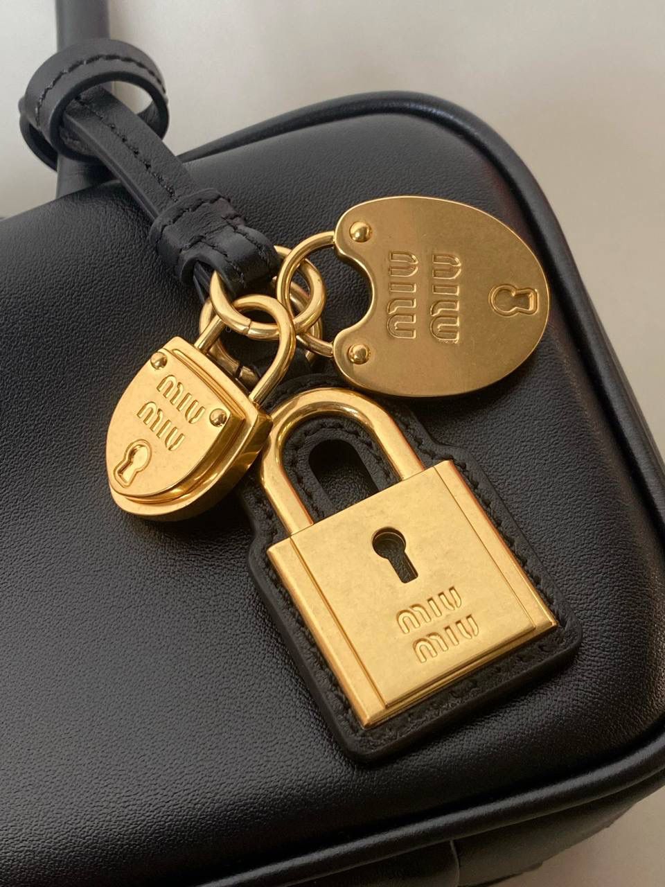 🈶黑色 𝗠𝗶𝘂𝗠𝗶𝘂保龄球| 吊饰版 说是公文包.更是保龄球！ 虽倆者都早已大火全网时髦圈哈哈 今年这只长手柄保龄球能买到就是赚到咯！ 细长的手柄整体更秀气了 还送了一串吊饰 是一把锁头还有一个爱心， 上面都有logo刻印很精致也很厚重 宝子们再也不愁买挂饰啦！ 28×11.5×8cm #F0010m