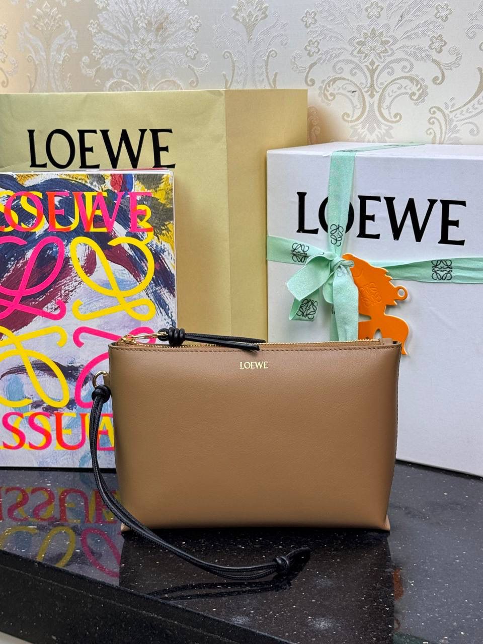 🎈𝘒𝘯𝘰𝘵 𝘛手拿包👜 —【橡木棕/黑色到货✅】 编码：522414 尺寸：𝟐𝟐.𝟓-𝟓.𝟓-𝟏𝟓.𝟓𝐜𝐦 全新撞色绳结拉链头和腕带设计，顶部拉链开合，内部人字纹帆布衬里以及2个皮隔层卡位，正面饰以品牌标志性烫金𝗟𝗼𝗴𝗼，方便时尚多用。