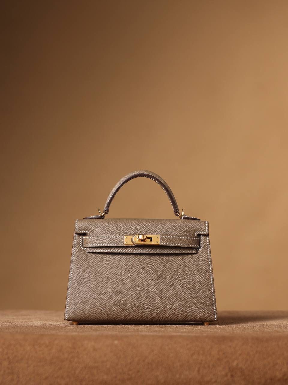 HERMES 爱马仕 Mini Kelly 二代 👜✨ Mini Kelly 二代 大象灰金扣 高清实拍图 尺寸：19*12*6cm Hermès爱马仕是世界著名的奢侈品品牌，1837年由Thierry Hermès创立于法国巴黎。爱马仕早年以制造高级马具起家，迄今已有180年的悠久历史。 其整个品牌从整体到细节以及专卖店，都弥漫着浓郁的以马文化为中心的深厚底蕴🎀