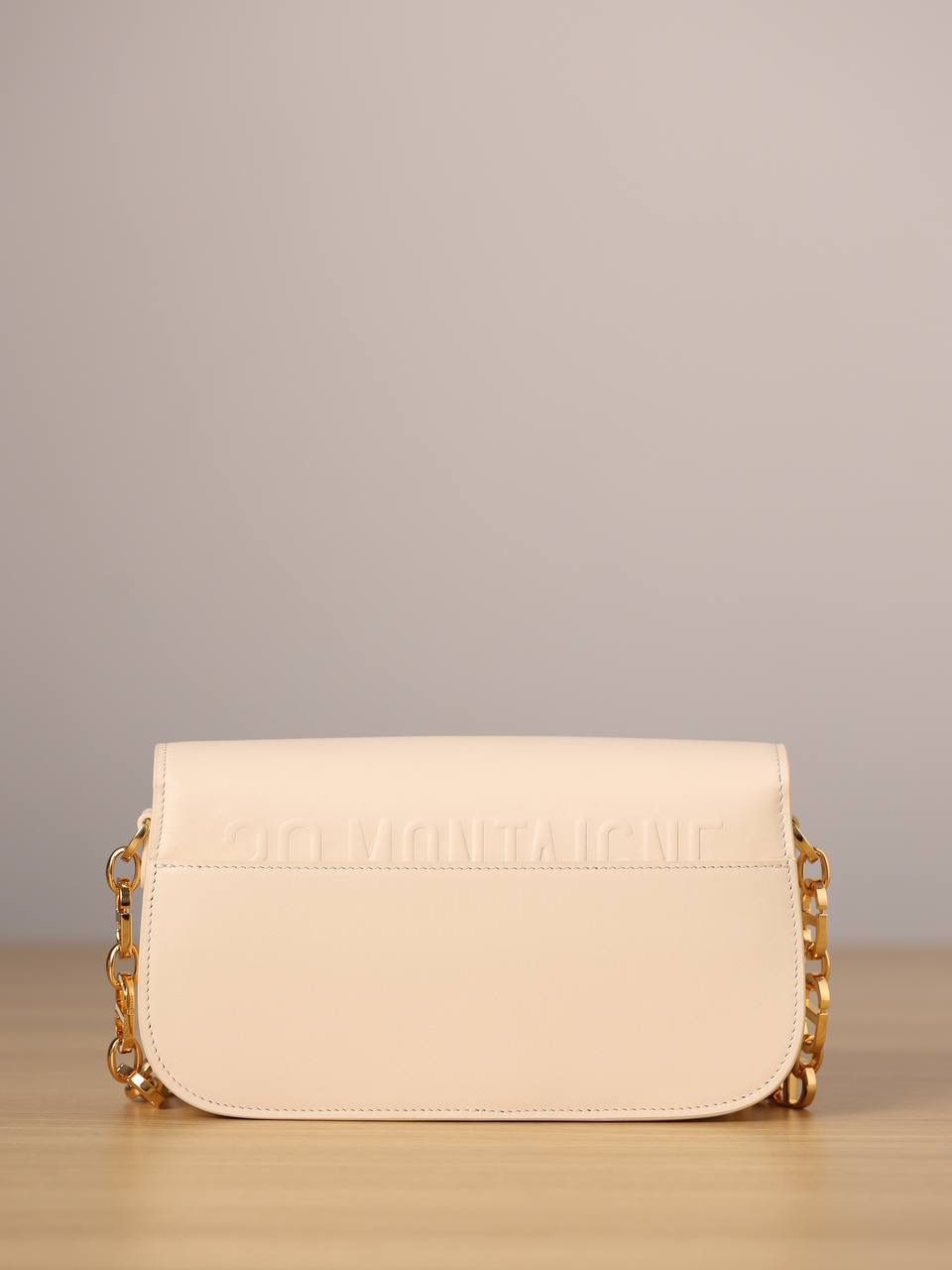 30 MONTAIGNE AVENUE 手袋 灰象牙色光面牛皮革👜✨ 独家渠道货 独家蒙田腋下包白色珐琅扣 尺寸：22.5 x 12.5 x 6.5 厘米 这款 30 Montaigne Avenue 手袋采用典雅的设计，提升此经典系列的格调。 采用黑色光面牛皮革精心制作，圆角翻盖曲线精致，饰以复古金色饰面金属 CD 扣环，灵感源自 Christian Dior 香水瓶的封口。 背面饰以压花 30 Montaigne 标志，搭配由金色饰面金属和与皮革同色调的珐琅链环交替组成的经典链条。 褶层设计，空间宽敞，廓形精致，可手提，肩背或斜挎。