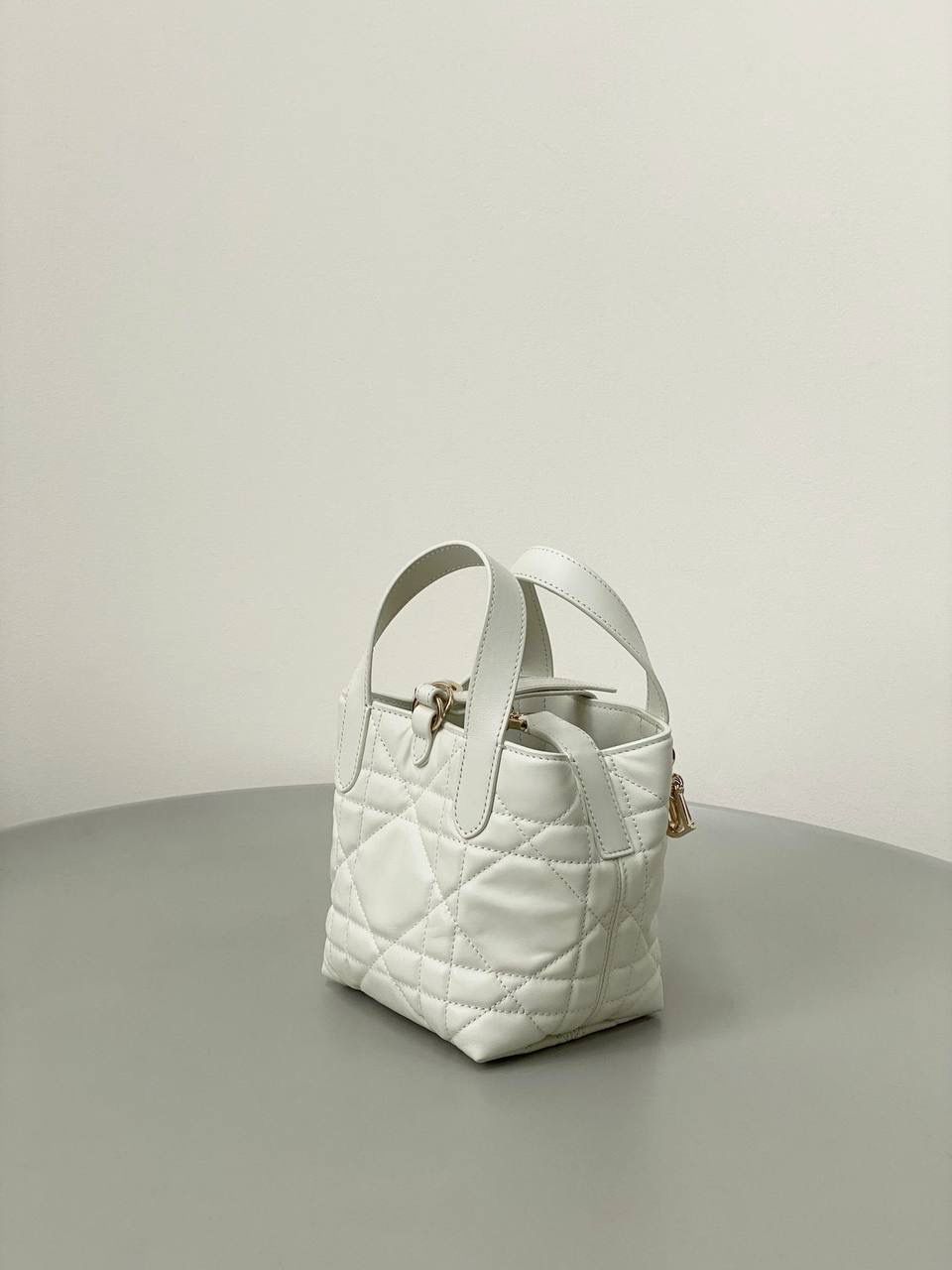 🈶白色，迷你 𝗗𝗜𝗢𝗥 𝗧𝗼𝘂𝗷𝗼𝘂𝗿𝘀新版竖款 火爆全网toujours缩小版来啦！ 看到真的心动得不行～ 实物就是常规迷你水桶大小， 真的可爱死 别说，包虽小但容量还挺大的 日常用品都能轻松装上 肩带长度也刚刚好，不挑身高 反正就是太乖啦！夏日必备 😍 13×15×12cm #M1272m