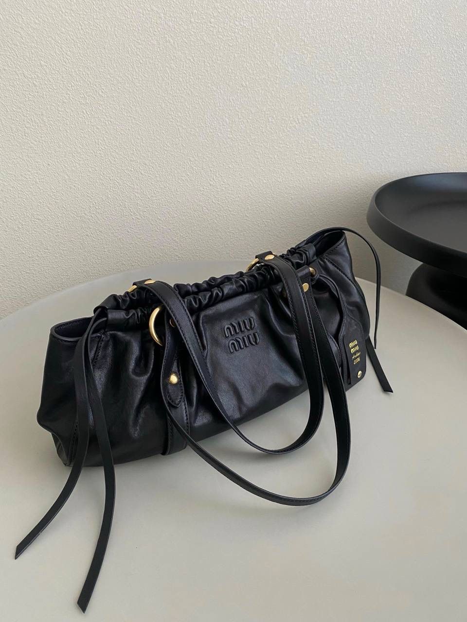 🈶黑色 𝗠𝗶𝘂𝗠𝗶𝘂 𝗡𝗮𝗽𝗽𝗮 饺子包 这只亮点在于包口用的是抽绳束口！ 抽绳可以随意调节，搭配的纤长双手柄可肩背或手提也可以随意捧在腰际'柔软的皮质加上不定型的设计，慵懒随性的调调一下就出来了 满满的vintgge复古感，既叛逆又不失格调'好喜欢啊 16×44×10.5cm #F0016m