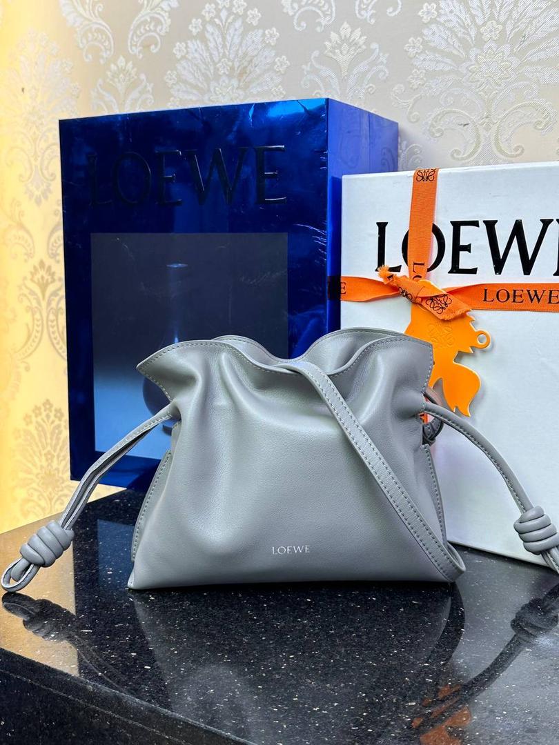 全新升级—𝙁𝙡𝙖𝙢𝙚𝙣𝙘𝙤出货啦✅ ❤️升级版福袋正面新增品牌烫金𝙇𝙤𝙜𝙤代替压印𝙇𝙤𝙜𝙤，肩带加宽同时增加两侧狗扣五金代替原本皮穿扣肩带，精致又便捷🥰 ❤️独家定制皮料五金，小牛皮皮质手感十分柔软且耐用，肩带🉑拆卸🉑调节，多种背法任你选择，容量超大，日常出行必备😍 ❤️独家品控，完全对版细节，全套礼盒🎁包装给你满满的仪式感🥰 迷你尺寸：𝟐𝟑.𝟗-𝟏𝟖-𝟗𝐜𝐦 款号：052030珍珠灰/新