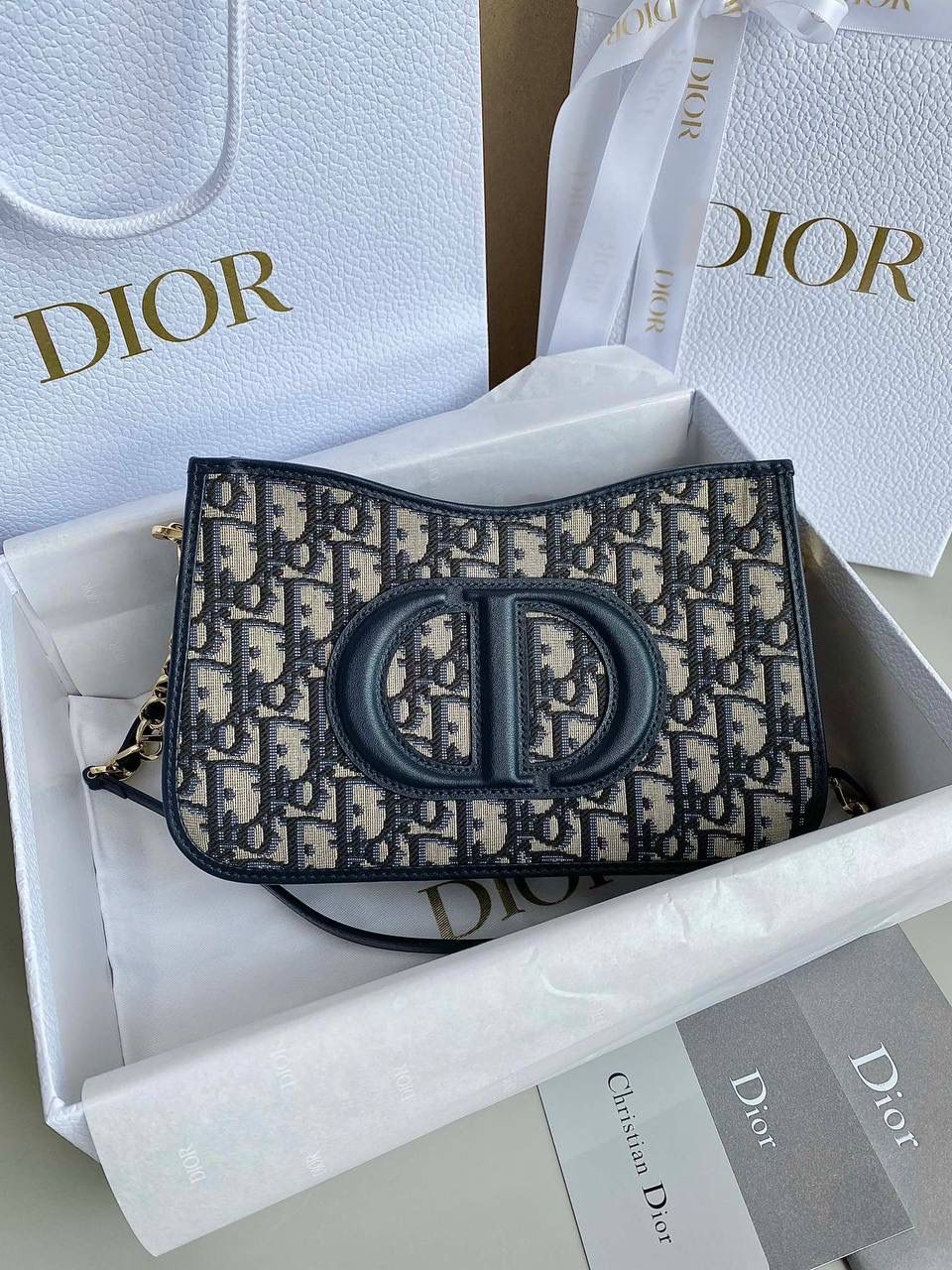 🈶老花蓝 𝗗𝗜𝗢𝗥 𝗦𝗶𝗴𝗻𝗮𝘁𝘂𝗿𝗲 𝗛𝗼𝗯𝗼 腋下包 Hobo在时尚圈一直占据着重要地位 全新包型又来咯，日常轻盈这只绝对OK 经典标志性logo又透着一股复古的调调 任何年龄段女生拿都不违和，非常有品 衔接的链条肩带也显得灵动随性不木讷了 很有法式优雅气息，冬天配大衣一绝 我可以天天背都不腻，通勤率只高不低 23.5×14.5×6cm，8131m