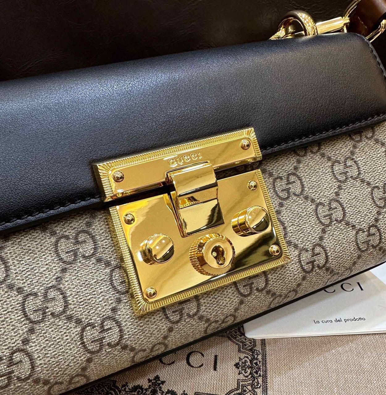 🔥𝐏𝐚𝐝𝐥𝐨𝐜𝐤 月光宝盒# ▫型号：735103 ▫️尺寸：22*11.5*7.5cm 👑经典之王𝙥𝙖𝙙𝙡𝙤𝙘𝙠又出新成员啦，标志性的小锁扣作为主打，保留了原样貌的设计‼️采用原厂黑棕牛皮➕G花面料 三合一的色彩尽显小女人气质的一款包。横版内存空间更大、各自好用、单肩/手挽/斜挎等。钢制耐磨五金，细节都源于正板打造。非常减龄哦！容量也足够日常外出必备小物件！788590