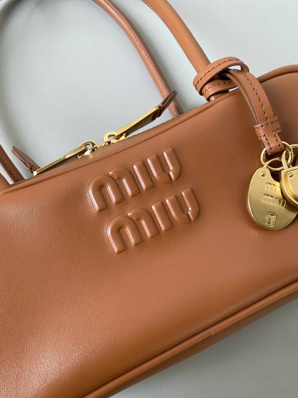 🈶干邑色 𝗠𝗶𝘂𝗠𝗶𝘂保龄球| 吊饰版 说是公文包.更是保龄球！ 虽倆者都早已大火全网时髦圈哈哈 今年这只长手柄保龄球能买到就是赚到咯！ 细长的手柄整体更秀气了 还送了一串吊饰 是一把锁头还有一个爱心， 上面都有logo刻印很精致也很厚重 宝子们再也不愁买挂饰啦！ 28×11.5×8cm #F0010m