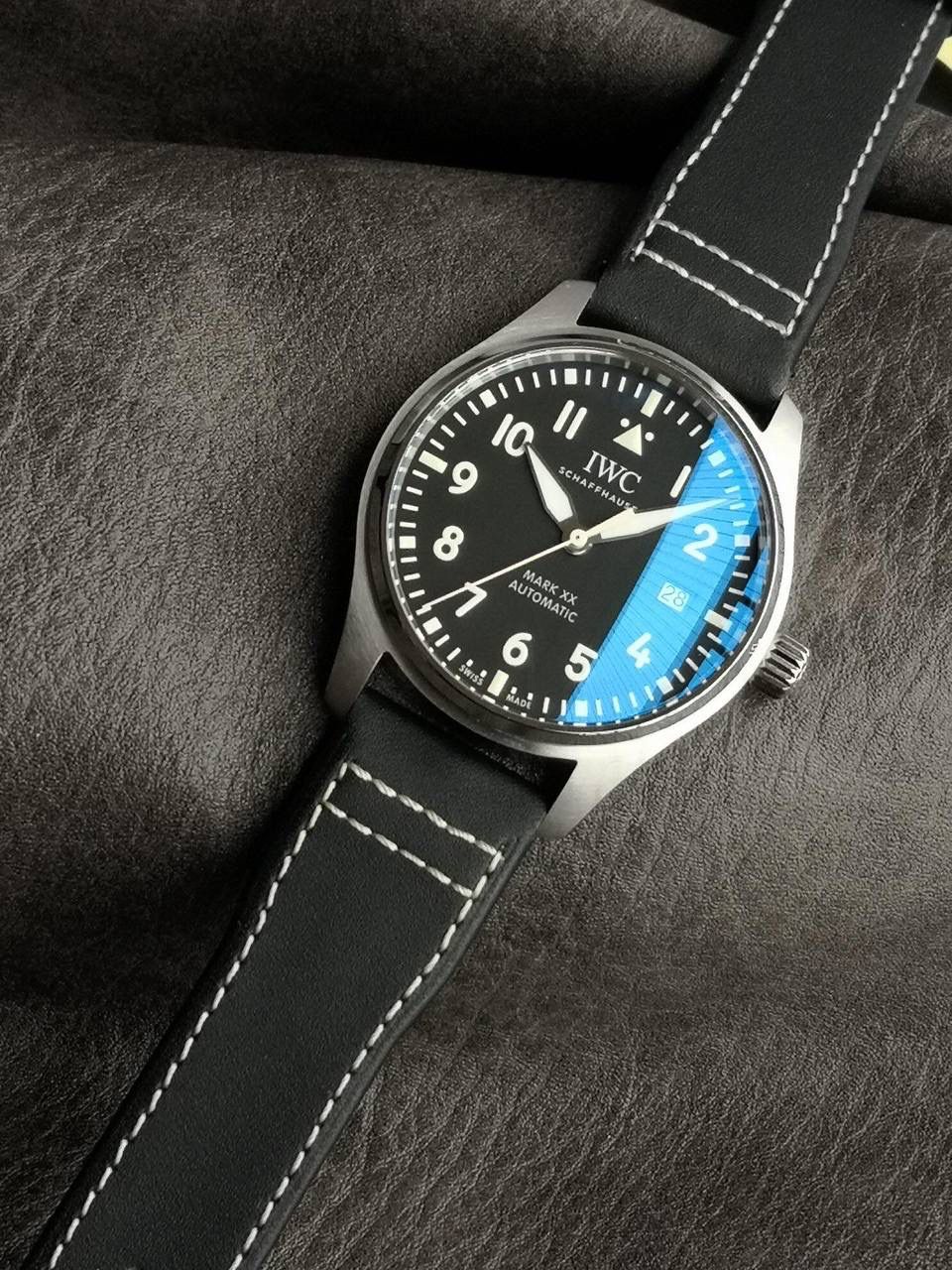 V7厂此款表盘与原装同样，仍配备通透度同步原装的进口双面防反光凸状蓝宝石镜面，刻度和时标依然保持白色印制工艺，与马克18的区别增加了3、6、9、12时标的长度，夜光条变化成夜光图层，阿拉伯数字时标则整体向表盘中央靠近，12点“IWC”标志略微上移，三角刻度也改为水滴夜光呈现全新的视觉比例。日历统一白底黑字台阶窗口也位同数字的一个圆轨道上，与背景形成更醒目对比，盘面上的荧光元素和指针在任何光线条件下，都能确保可读性。时针、分针现在经过镀铑处理，并且指针针尾有稍微做弯（注:有别于市场版本，v7细节把控向来严谨，放大来看亦无可挑剔） V7厂独家专用马克进口牛皮，其材料，做工，佩戴感100%同步原装，全新开模的表扣，打磨刻字功底扎实，表扣与表带均采用自拆装置，实用功能是EasX-CHANGE®简易更换系统，无需借助其他工具，可以轻松更换链带，难辨雌雄。这也是有别与市场版本特点。 V7厂仍采用进口瑞士全新SW300机芯，性能同样出色，精准恒久，无返修烦恼！V7亦同时提供亲民版的海鸥2892稳定版供选，其外观细节均与瑞士版本一样。