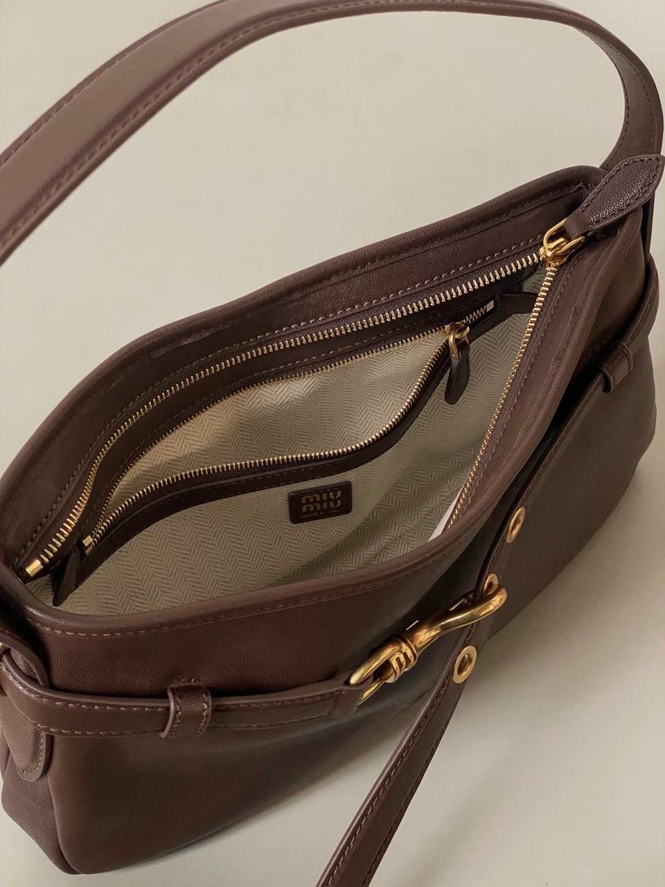 🈶石楠木色，小号 𝐌𝐢𝐮𝐌𝐢𝐮 𝐀𝐯𝐞𝐧𝐭𝐮𝐫𝐞腋下包 不得不说缪缪的美丽层出不穷！今年这只Aventure Nappa腋下包 看似平平无奇上身却意外好搭耐看 有点小复古又有点小机车， 就很值得夸赞一番 东西不用装太满，随性的褶皱感很戳心巴 自重非常轻，宽肩带设计一点都不溜肩容量空间也不错，日常东西都放的下 迷你iPai都👌🏻尊嘟人见人爱不带吹的！ 33×19×5cm #F0021m