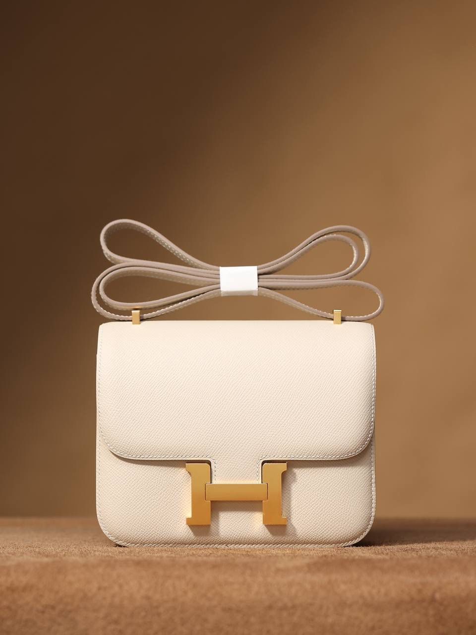 Hermes 爱马仕 #Constance 19奶昔白金扣👜✨ Epsom牛皮 单肩斜挎包 尺寸：19*15*4 cm 这款采用的是Epsom牛皮,纯原皮，和专柜用的是一个渠道的真皮 什么是Epsom牛皮？ 皮质：ep皮/手掌纹、一岁以上的公牛皮 软硬度：偏硬 纹理：皮面颗粒小的细腻皮纹，有点光泽感 特点：硬朗有细纹的牛皮皮质。细纹是进过后期处理的，比较硬质立体，长期贮存也不容易变形。自重轻，不易刮伤，非常耐磨实用。 所以每个H的款式用的皮都不一样，都是非常有讲究的✅