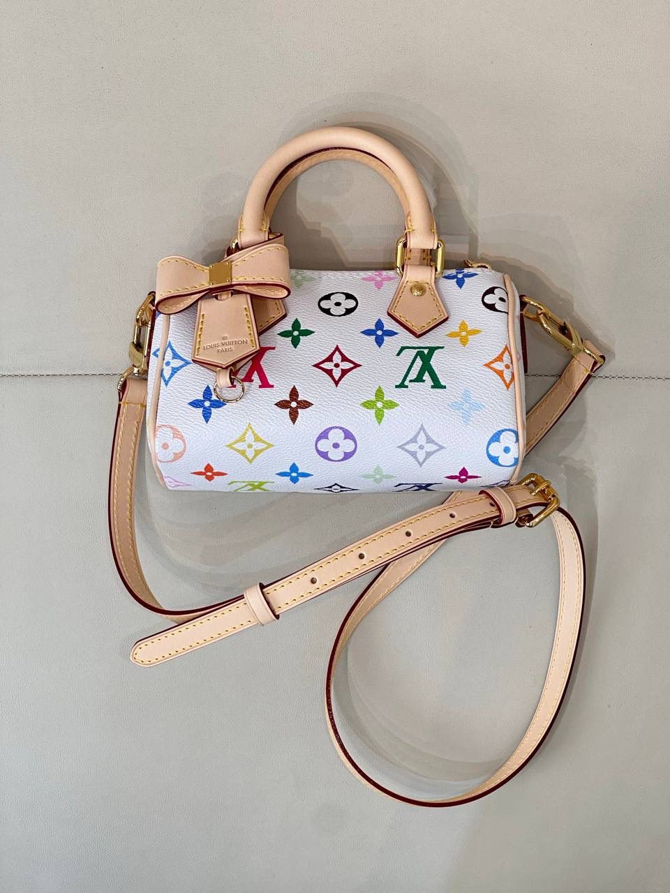 LV村上隆联名白三彩Nano Speedy来啦！姐妹们快看这个神仙包包！👜🌈 白色打底+彩色老花图案，配上祖传小锁头钥匙包，简直是《Mean Girls》千禧辣妹的标配！全新数码印花绝绝子，太阳花和熊猫都像要跳出来，阳光下自带ins滤镜特效！别看它巴掌大，手机口红💄钥匙全塞得下，从此打脸那些说mini包不实用的人！ 尺寸：16-10-7.5cm