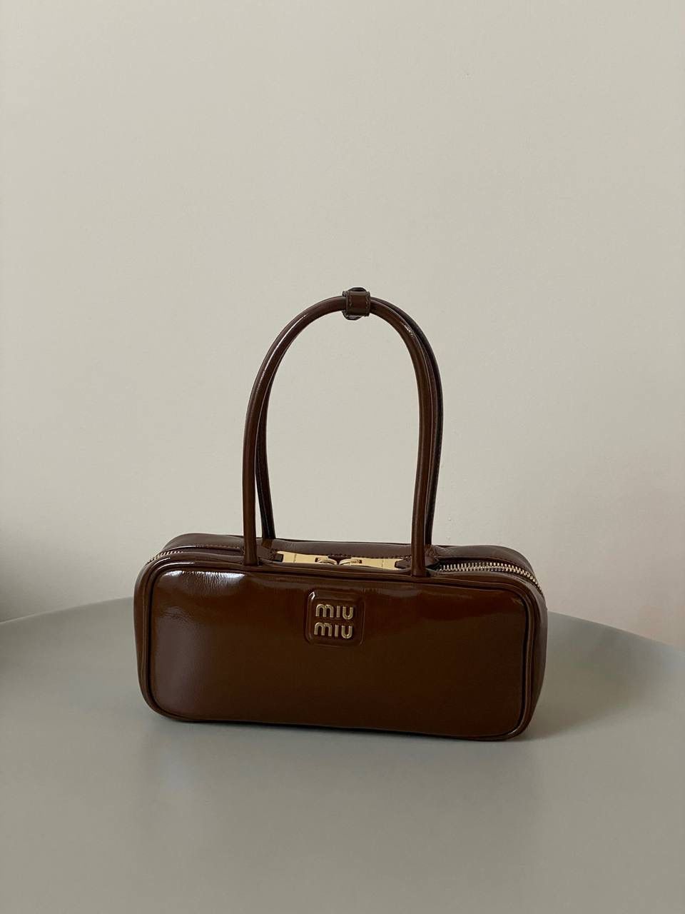 🈶漆皮紫檀木色 𝗠𝗶𝘂𝗠𝗶𝘂保龄球| 新面料来啦 漆皮色泽光亮自然饱满～ 皮面透着的皱纹仿佛湖面上的水波纹 无论视觉还是手感，质感都很绝！ 27×12×8cm，#F0011m