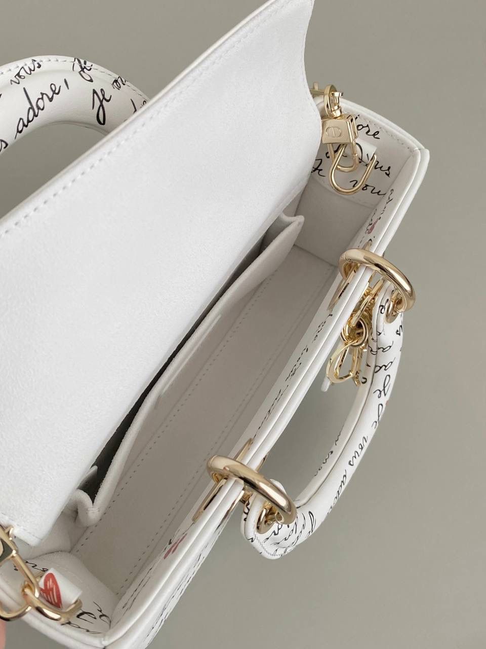 爱心白🎀𝗗𝗜𝗢𝗥 𝗗-𝗝𝗼𝘆小号 七夕限定，更是每一天的爱意限定 情书💌款这种淡淡的色调好梦幻 从印花到纯色都散发着治愈的气息 刻印的纹理感，伸手可触 连绵不断的法语我爱你'点缀着爱心❤️ 是写满了法式浪漫的包包呀！ 请拥有，这独一份的爱意 22×12×6cm