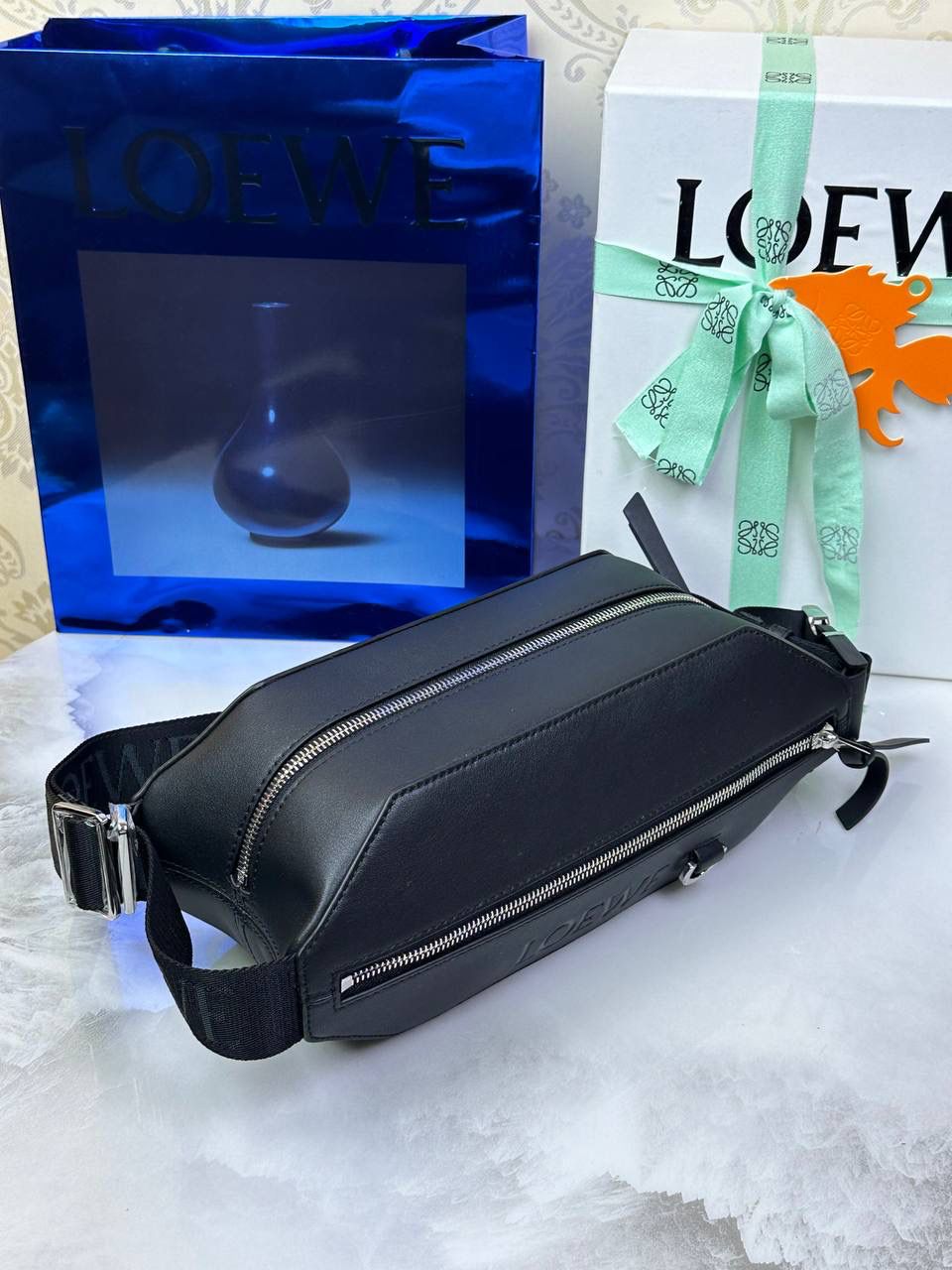 ———变形𝙎𝙡𝙞𝙣𝙜斜挎腰包👜 （新款黑色到货👉🏻） 尺寸：𝟑𝟐.𝟓-𝟗-𝟏𝟐.𝟑𝐜𝐦 编码：060402 👉🏻正面饰品牌标志性𝙇𝙤𝙜𝙤，搭配可调节𝙇𝙊𝙀𝙒𝙀织带，可打开以改变手袋容量并实现多种携带方式⭐️ 👉🏻经典小牛皮，皮质细腻柔软。可斜挎或者作为腰包携带，内里容量大，可容纳日常出行所需⭐️ 👉🏻独家全套礼盒套装➕独家高端品质，好货全在我手，送礼佳品⭐️