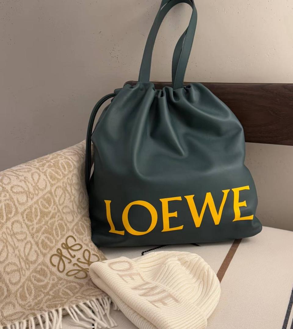 🎈全新福袋𝗙𝗹𝗮𝗺𝗲𝗻𝗰𝗼 𝗧𝗼𝘁𝗲 ——【常青色到货✅】 尺寸：𝟒𝟔-𝟏𝟐.𝟓-𝟒𝟏𝐜𝐦 编码：052026【配防尘袋，没有盒子】 ❤️以经典Flamenco系列手袋👜为基础，新款Flamenco Tote手袋采用加长廓形，正面饰品牌超大对比色𝐋𝐎𝐄𝐖𝐄标志，外部进口Napa小牛皮，内里绒面设计，整个包手感超级柔软舒服。 ❤️超大容量设计，磁扣开合，1个拉链内袋，可肩背或者手提✌🏻，可放15寸电脑💻，出行通勤必备，无论男女都🉑轻松驾驭。